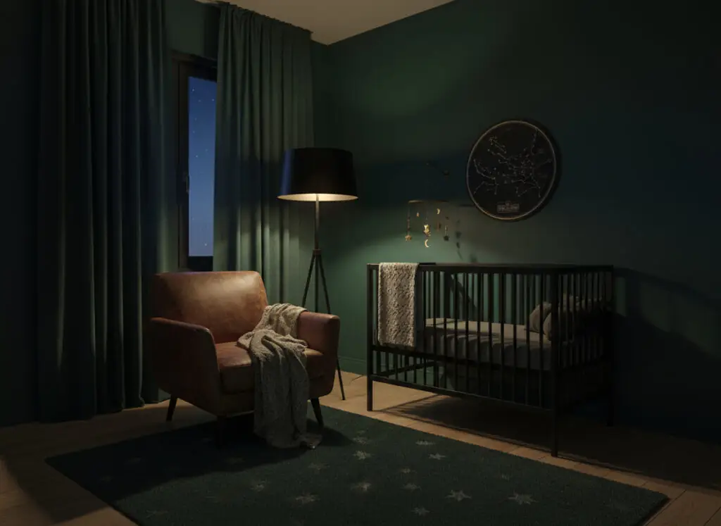 Dimly lit nursery with deep green walls, black metal crib, and brown leather armchair.