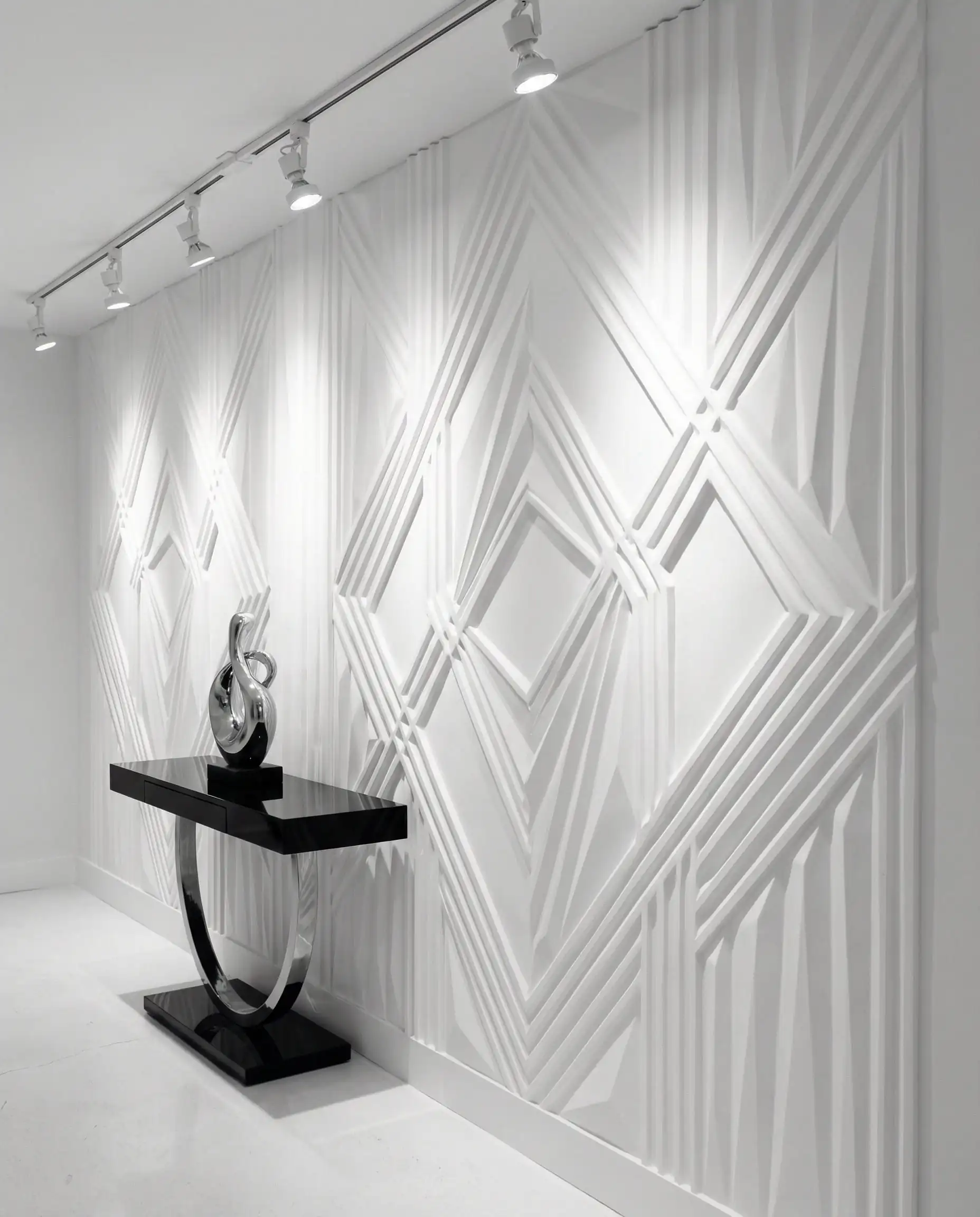 Papier peint géométrique en relief 3D blanc sur blanc avec des ombres profondes dans un couloir moderne.