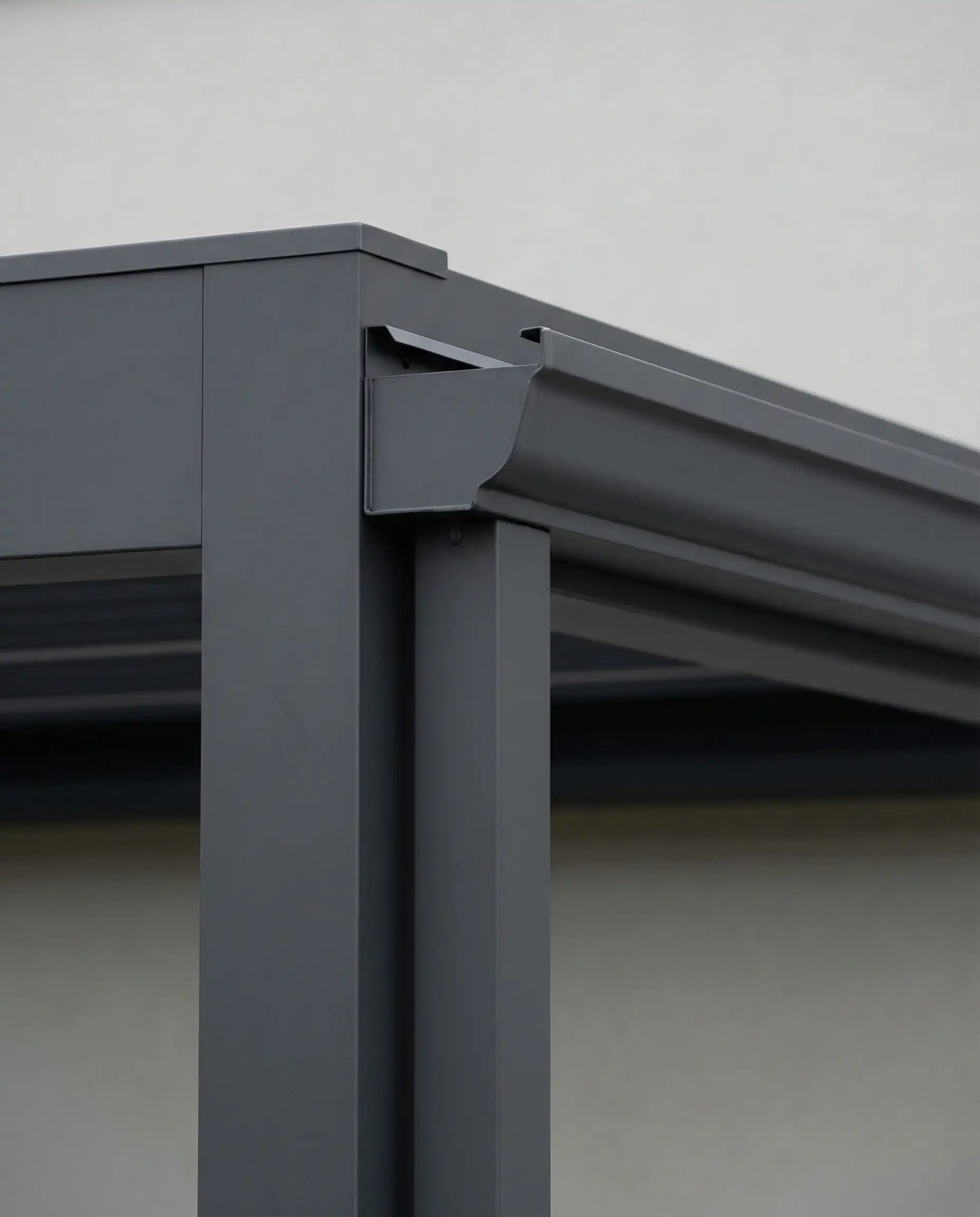 Close-up architectural detail of a matte charcoal aluminum pergola structure.
