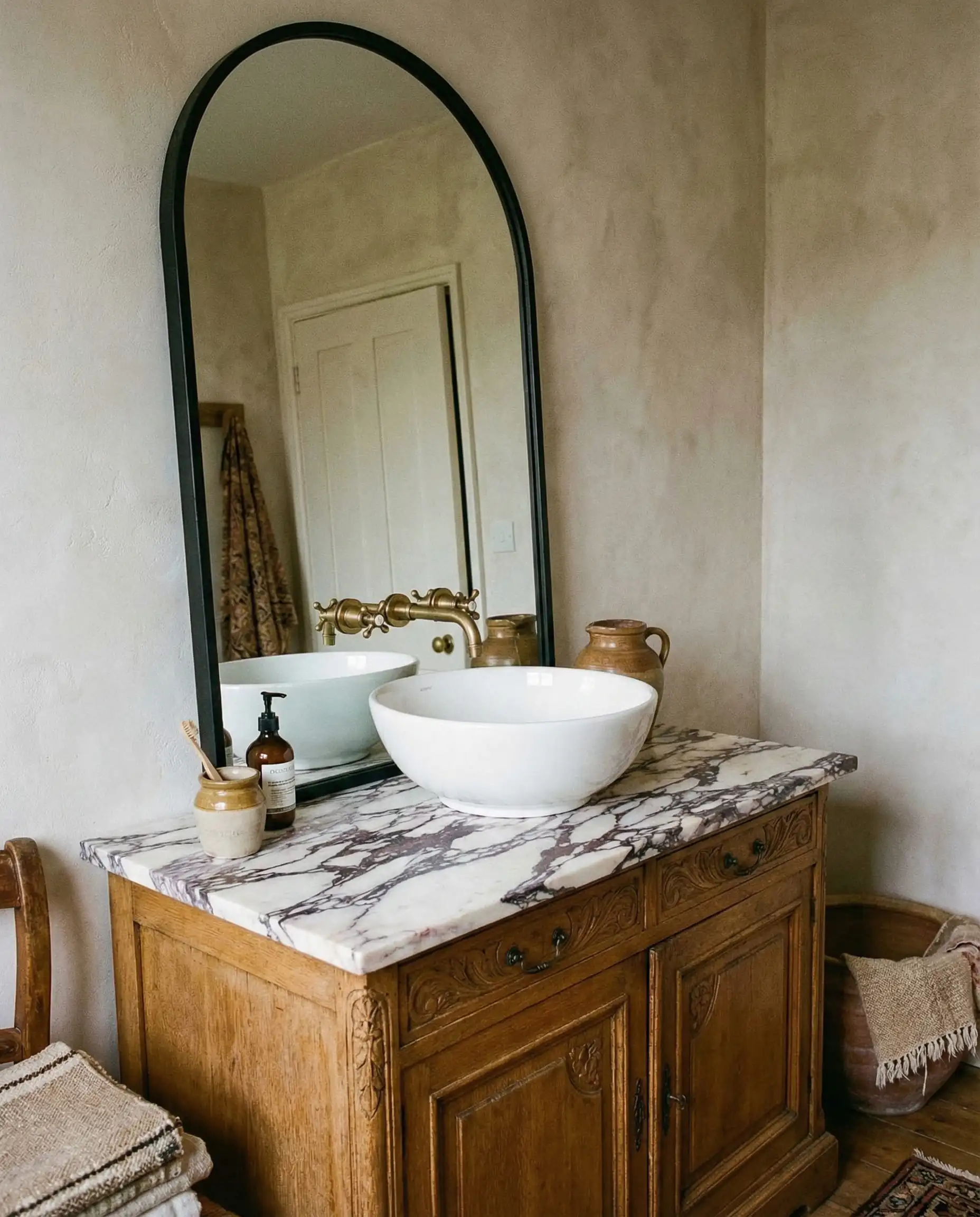 Repurposed antique oak dresser converted into a bathroom vanity with marble top and vessel sink.