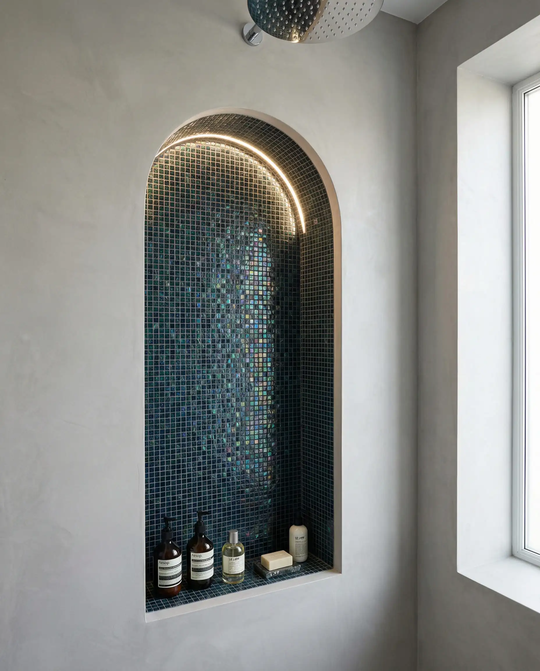 Un espace douche élégant et moderne doté d'une niche encastrée profonde et arquée.