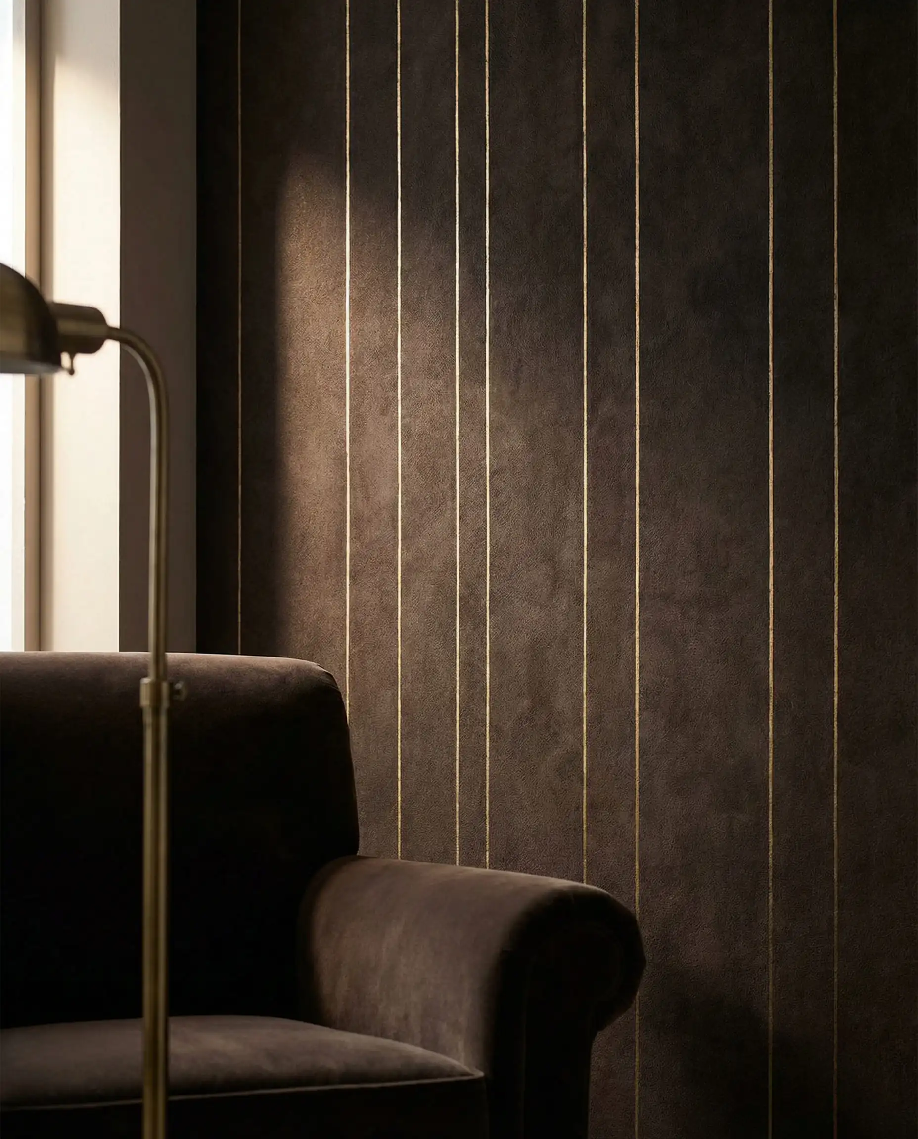 Detail of espresso brown wallpaper with delicate brushed gold metallic pinstripes reflecting light.
