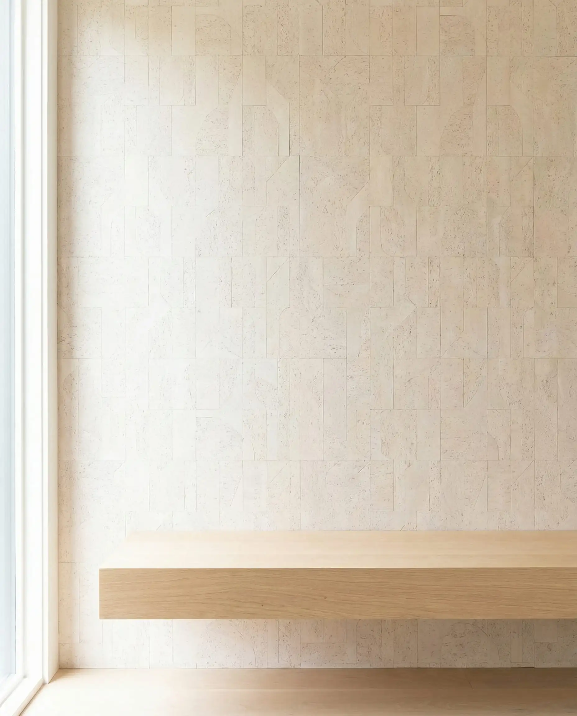 A bright entryway featuring a wall of modern, geometric cork tiles in a bleached birch color. This entryway features Pale blonde, bleached white, and light natural wood tones and a airy, sustainable, modern atmosphere.