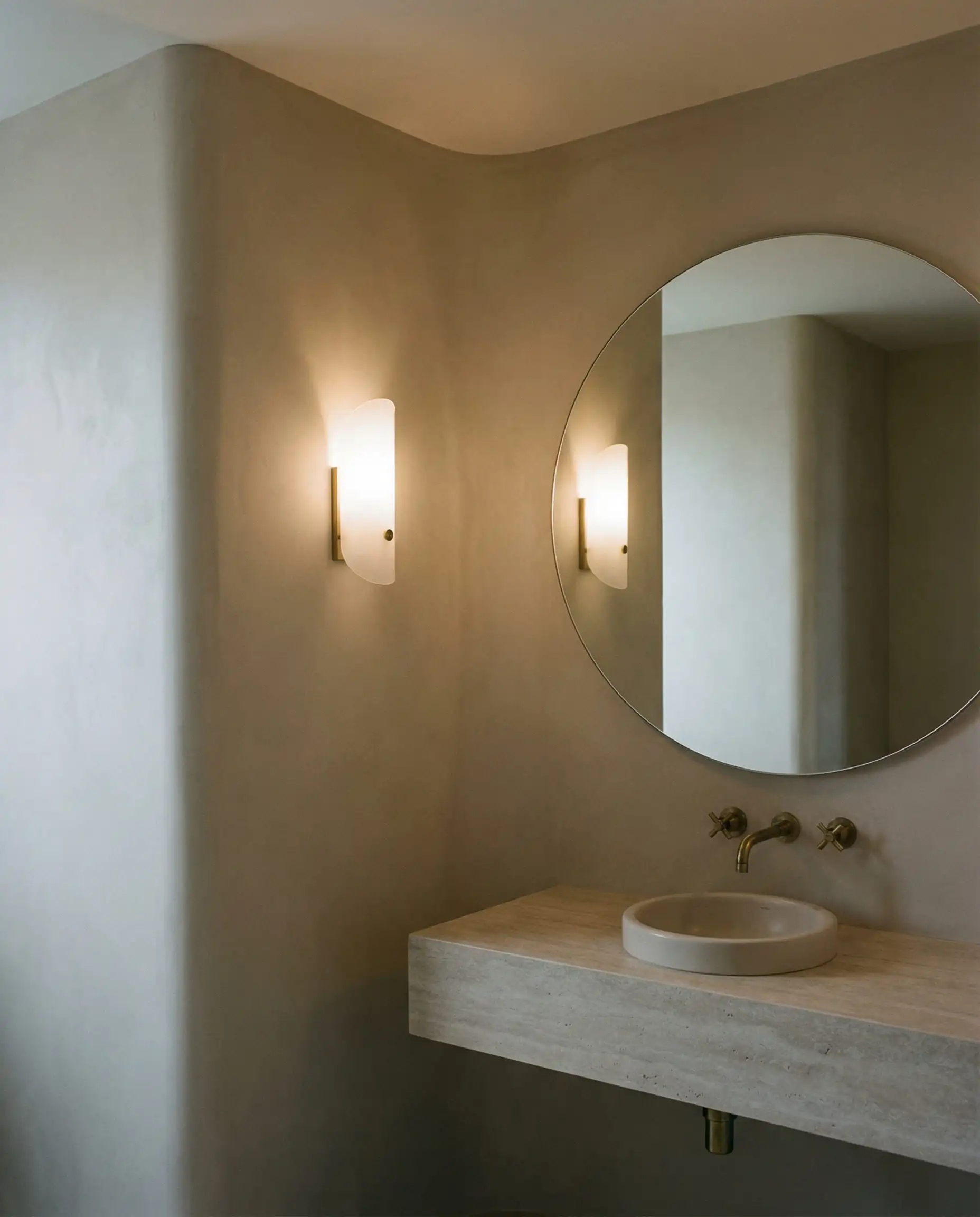 Une salle d'eau accueillante présentant un mur entièrement courbé fini au plâtre avec des bords doux et arrondis au lieu de coins vifs.