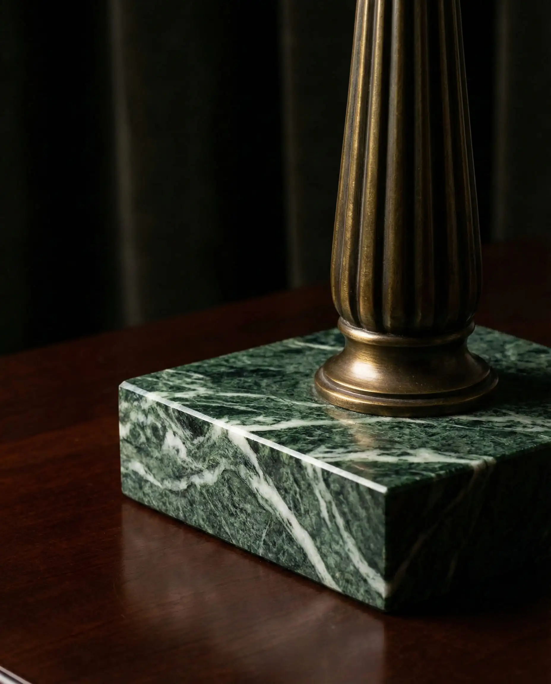 Detail shot of a heavy green marble base and fluted antique brass stem on a Neo-Deco style table lamp.