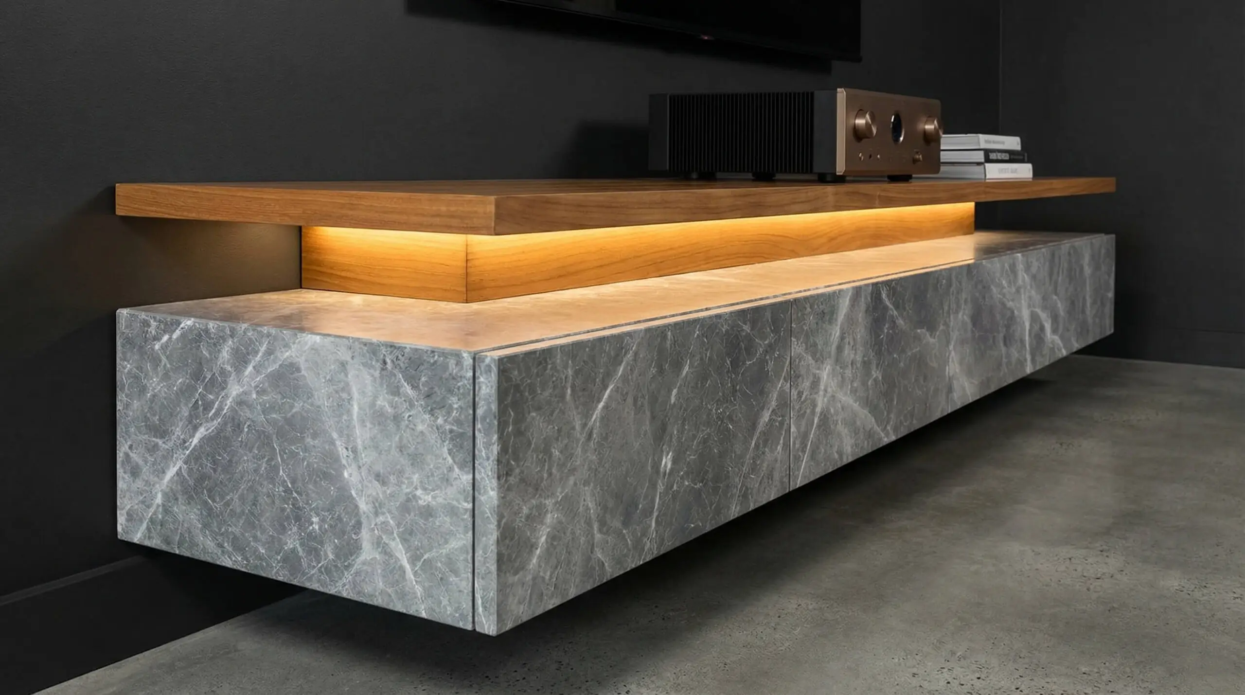 Luxury floating media console design featuring overlapping layers of grey Pietra marble and warm teak wood with hidden LED lighting.