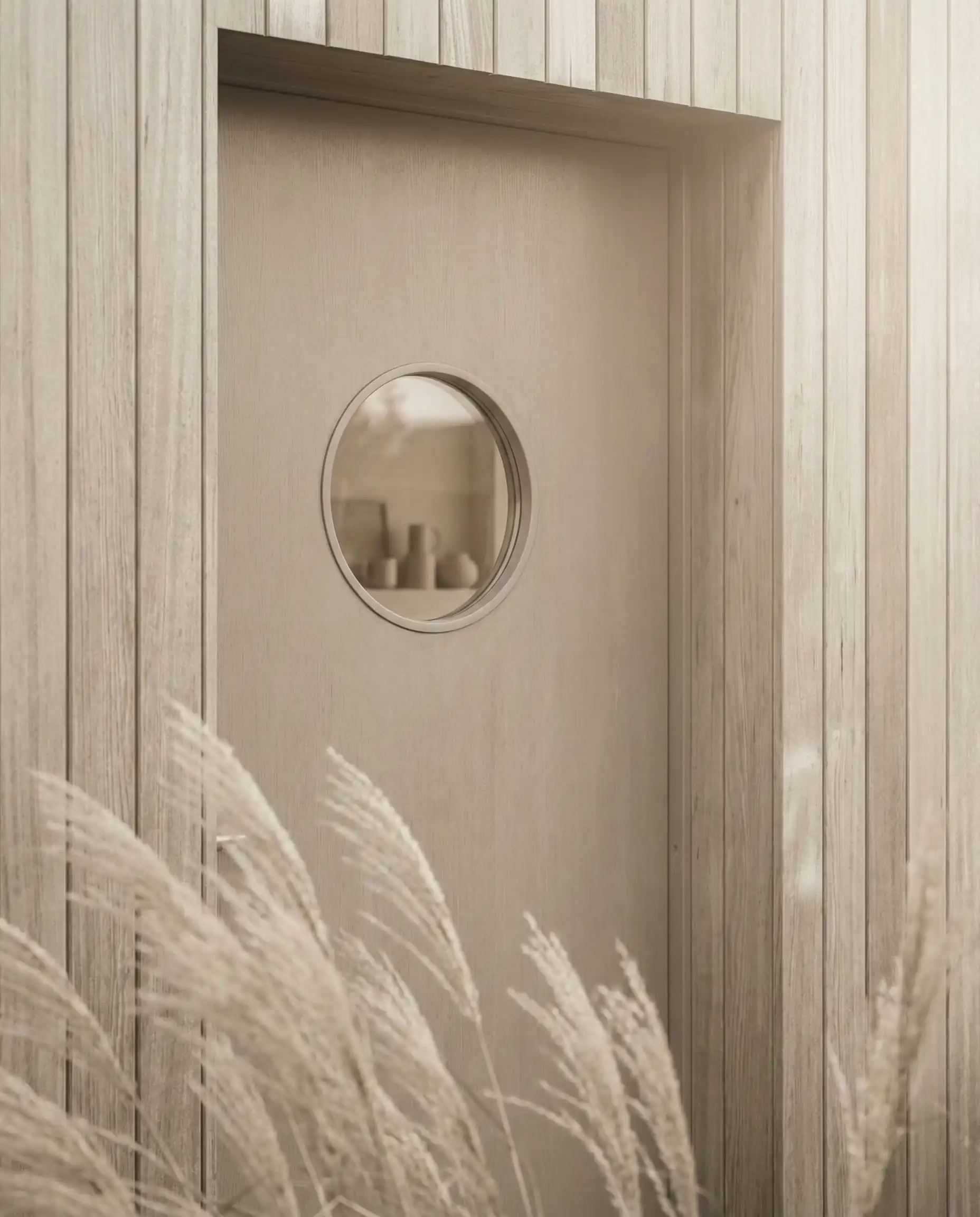 Minimalist beige front door matching vertical cedar siding with a round porthole window.