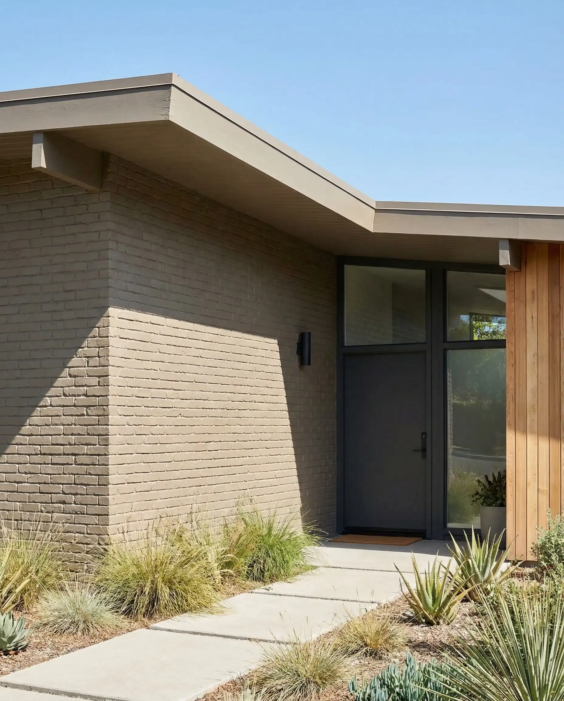 Mid-century home with brick walls painted in a solid, opaque warm greige masonry paint.