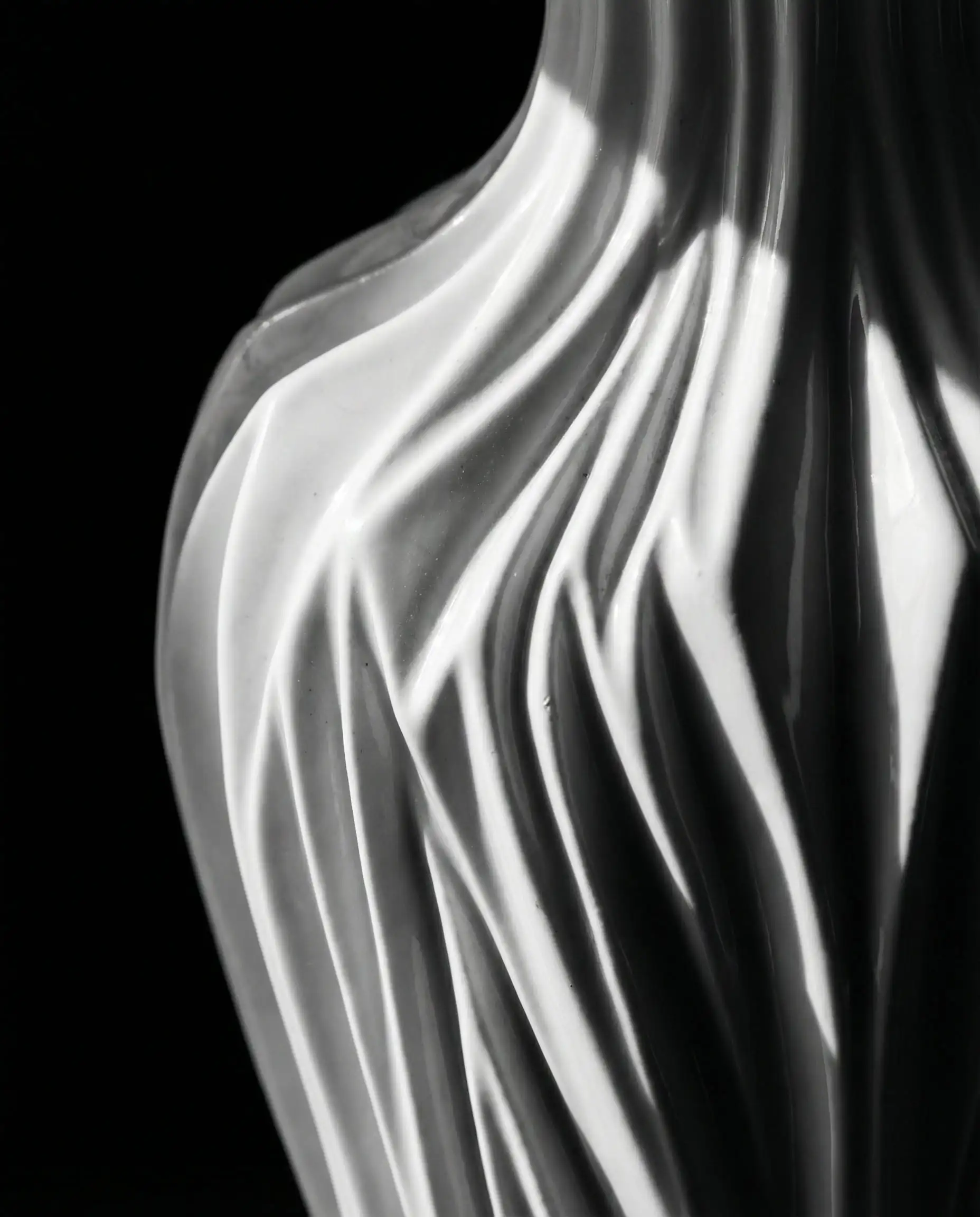 Macro detail shot of a hard porcelain lamp base molded to look exactly like tightly pleated soft silk fabric.