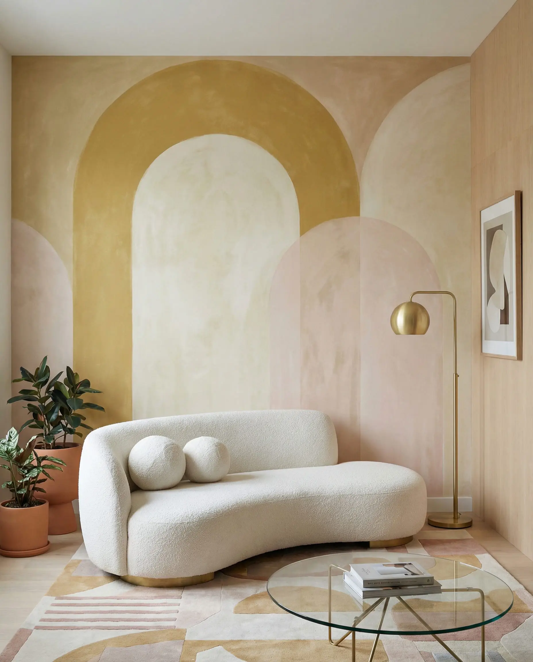 Feature wall with large matte arch pattern wallpaper in mustard yellow and cream, styled with a curved sofa.