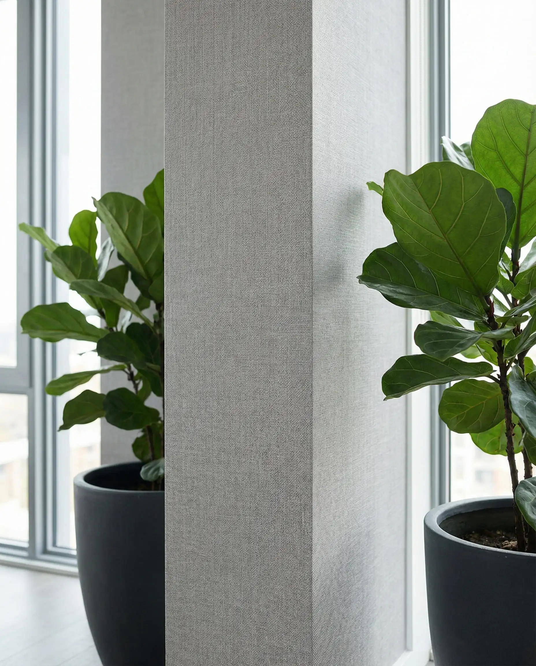 A close-up detail shot of the seamless edge of a non-woven, PVC-free wallpaper installation in a high-traffic area. This interior features Soft grey, charcoal, and vibrant green from the plant tones and a durable, clean air, modern atmosphere.