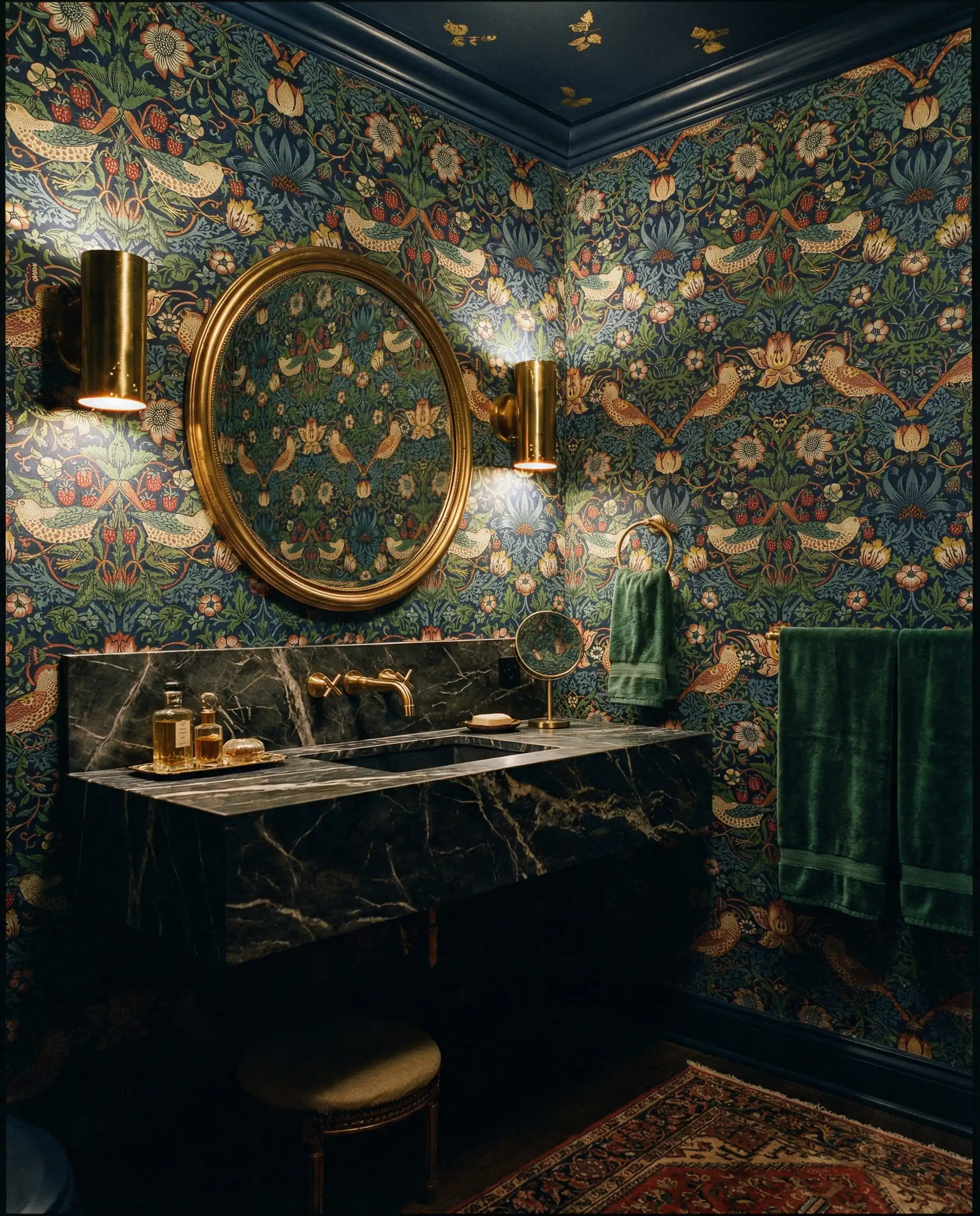 Papier peint floral style William Morris vert émeraude foncé dans une salle d'eau de luxe avec des accents dorés.