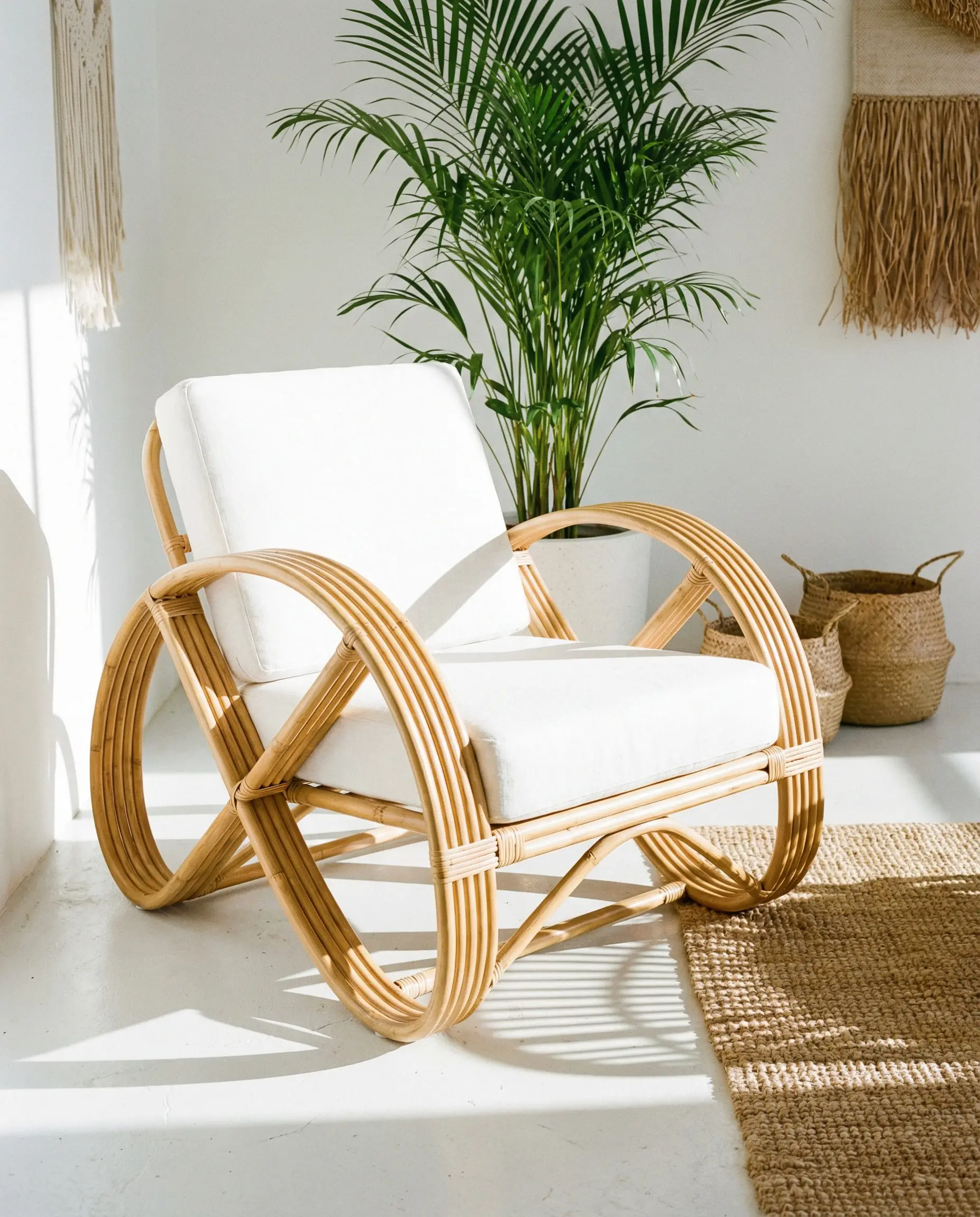 Bent bamboo accent chair casting shadows on a white floor.