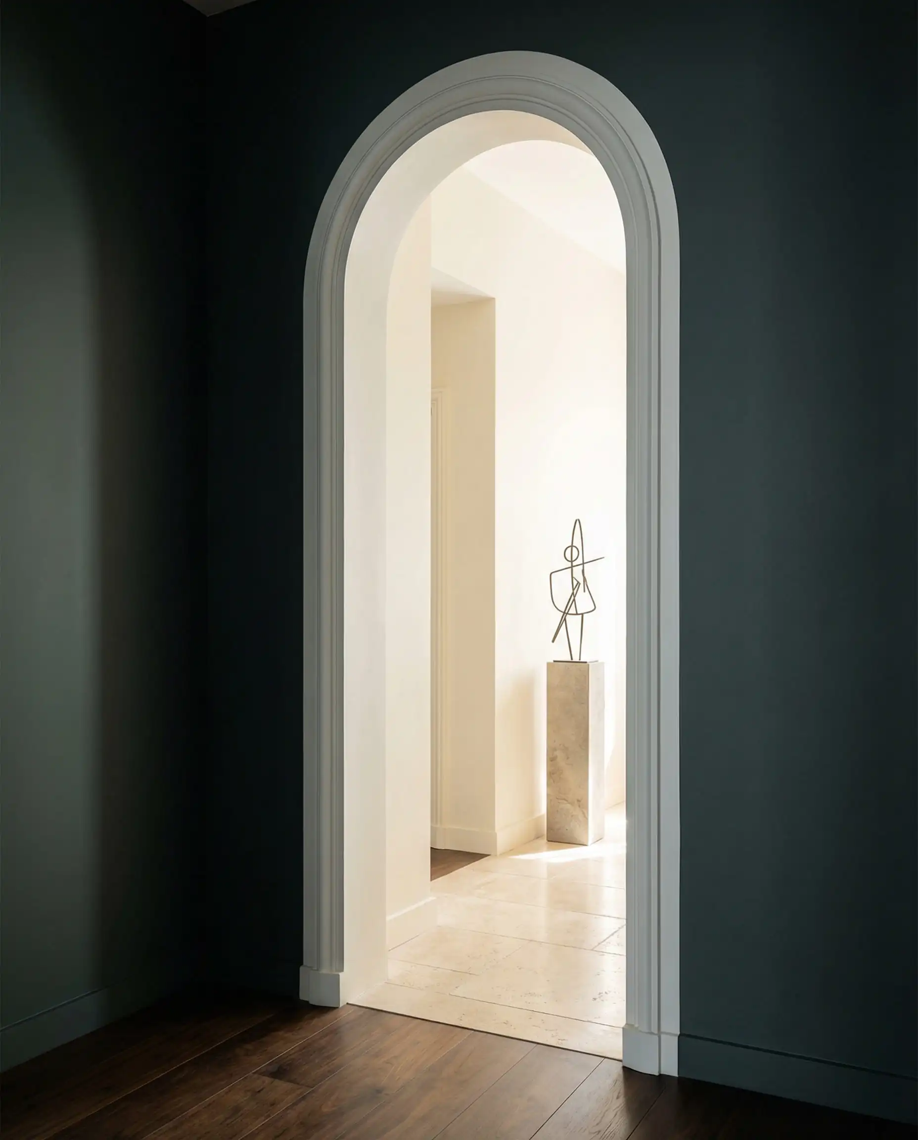 Interior doorway showing the contrast between dark Behr Hidden Gem walls and bright Behr Blank Canvas hallway.