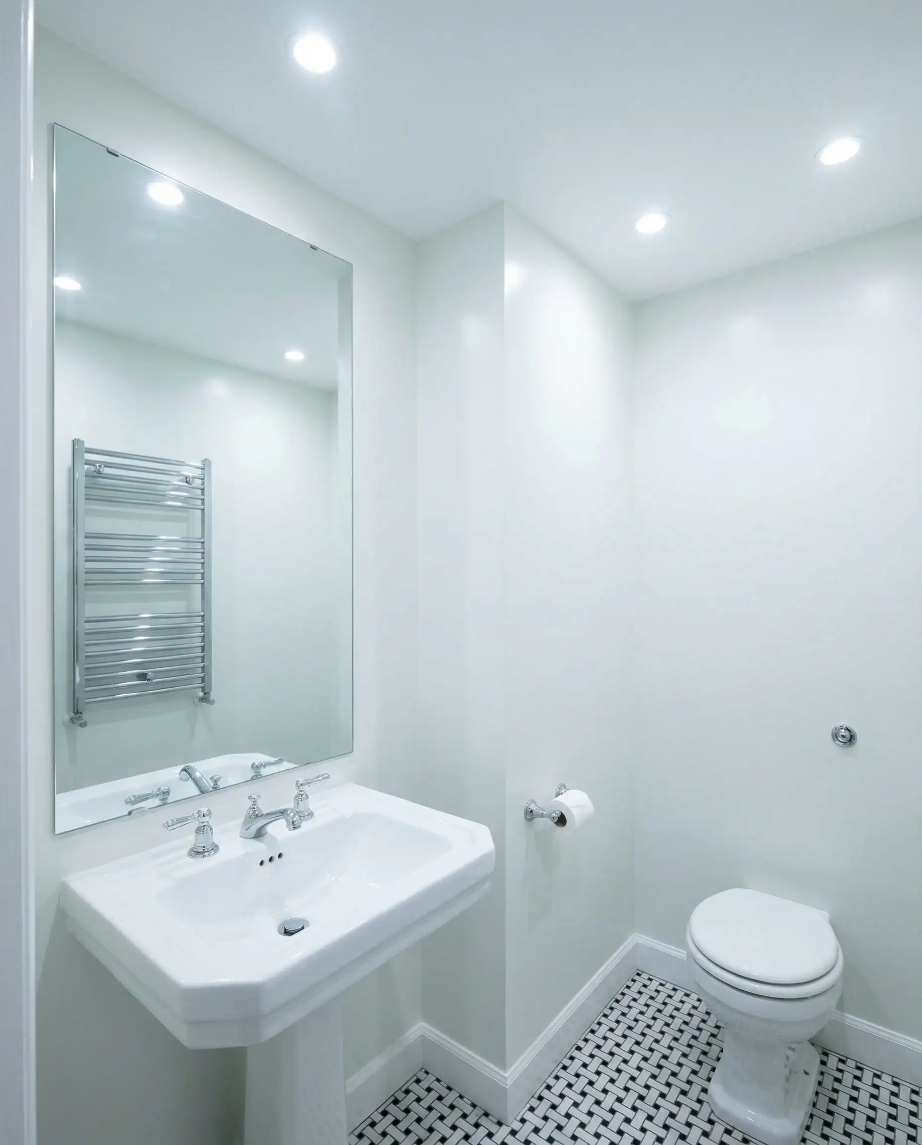 Small windowless powder room painted in Benjamin Moore Chantilly Lace to maximize brightness.