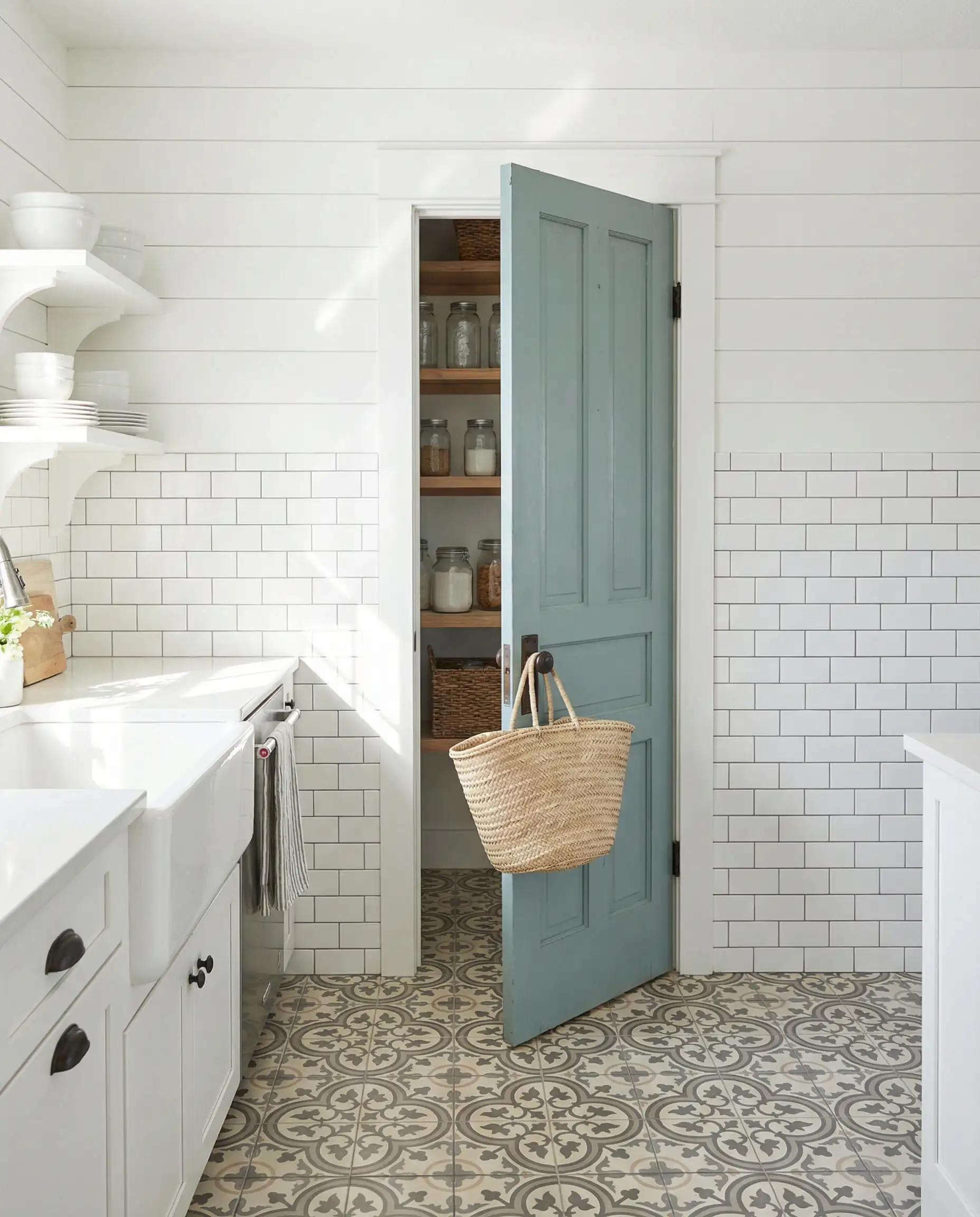 White farmhouse kitchen with a vintage pantry door painted in dusty blue-green.