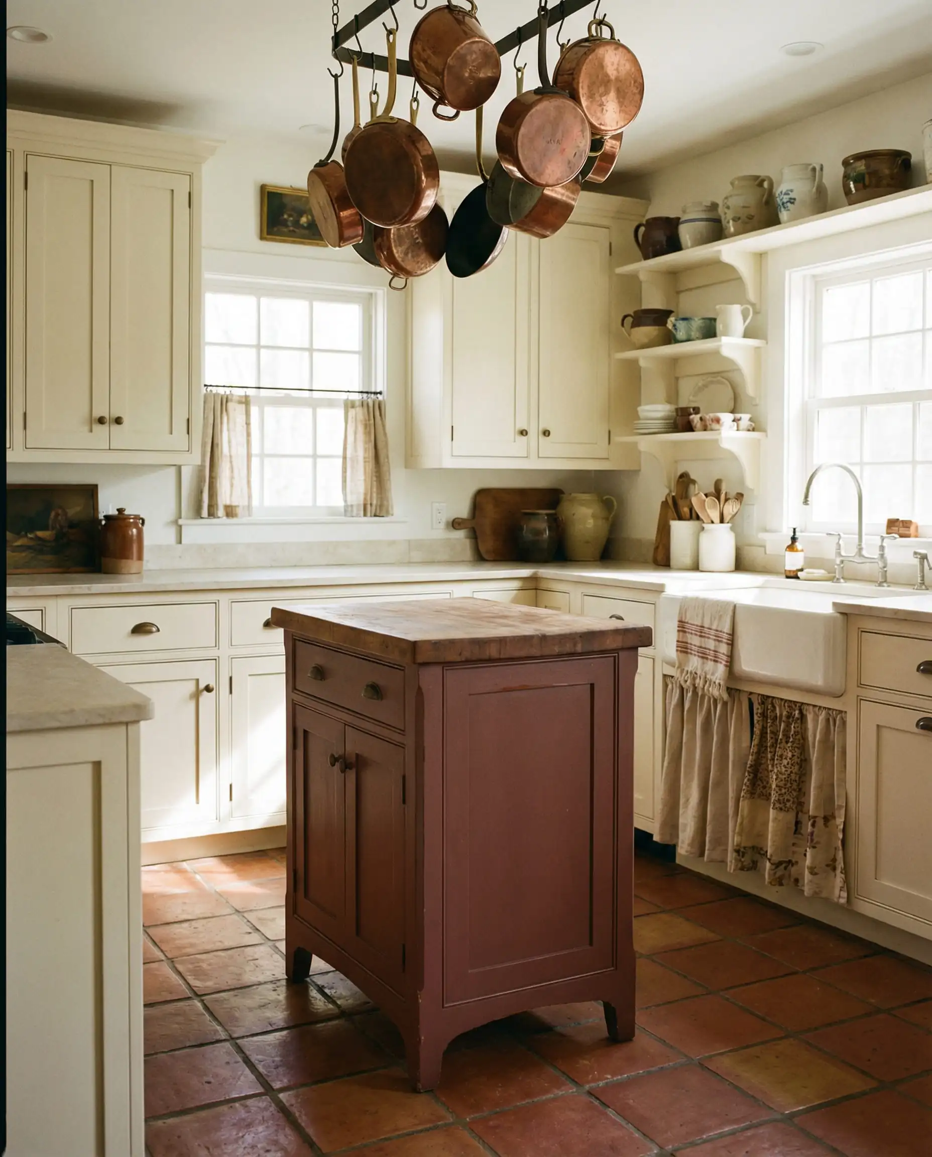 Small cottage kitchen island painted in Sherwin-Williams Carnelian SW 7571 with copper pots.