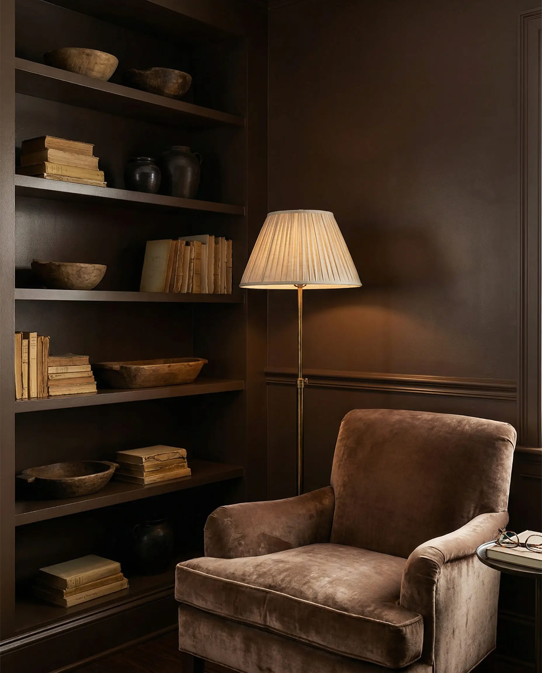 Cozy reading nook with color-drenched deep mocha walls and built-in shelves.