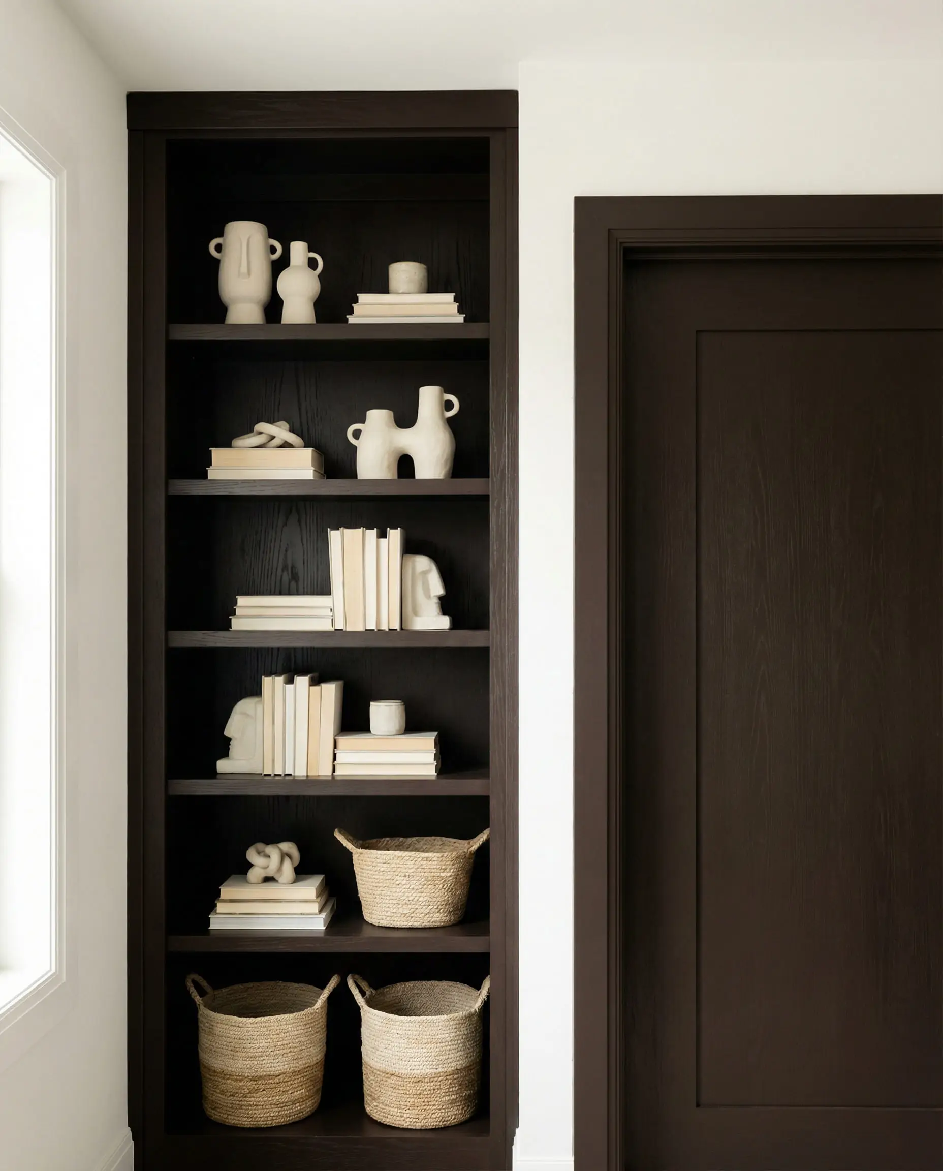Built-in bookshelf painted espresso brown contrasted against white walls.