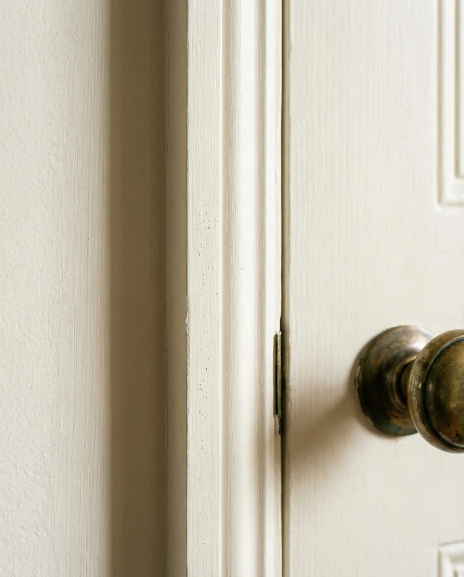 Macro study of a door casing painted in Farrow & Ball Wimborne White showing the estate emulsion finish.