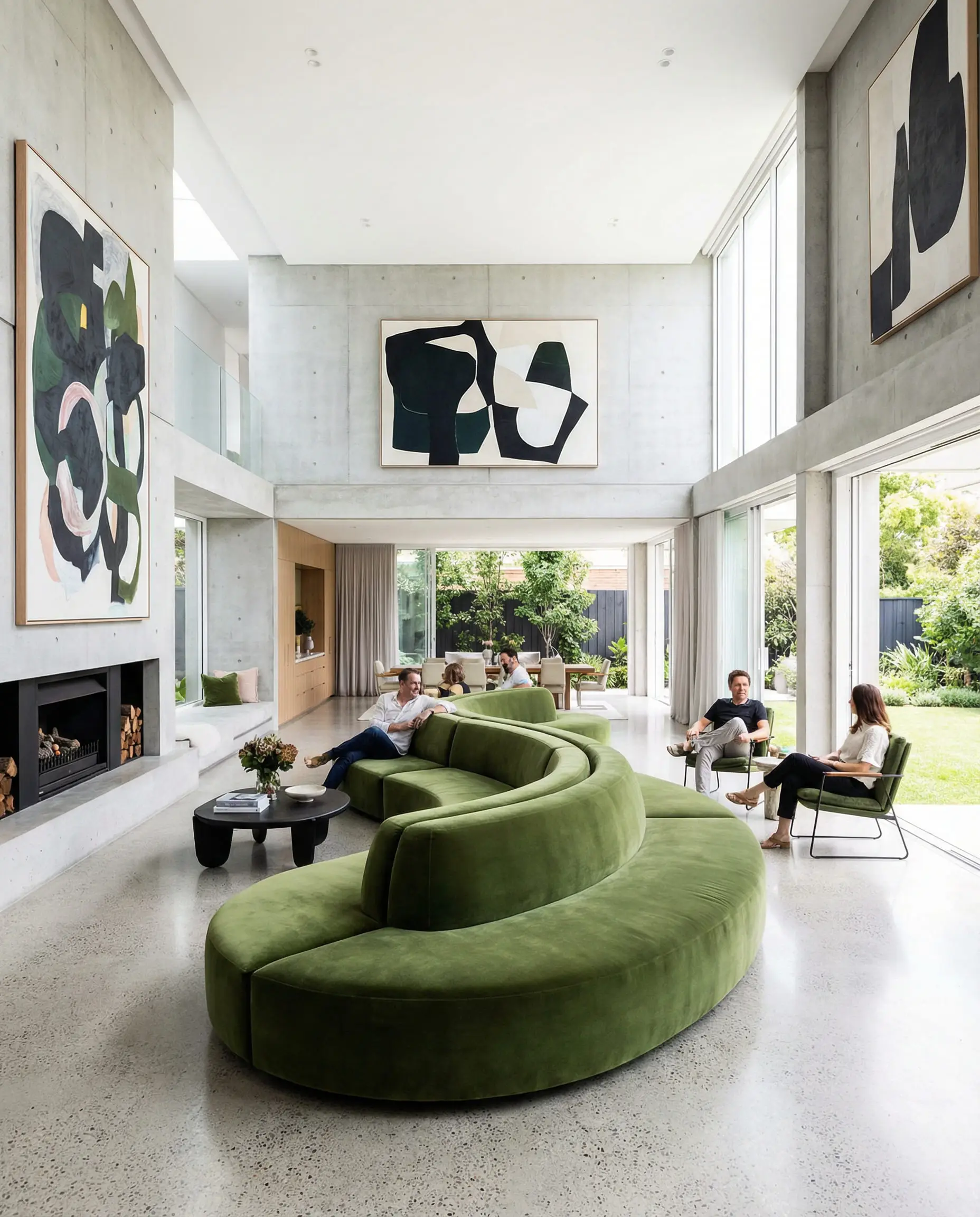 Large S-shaped serpentine sofa in moss green velvet dividing a large room.