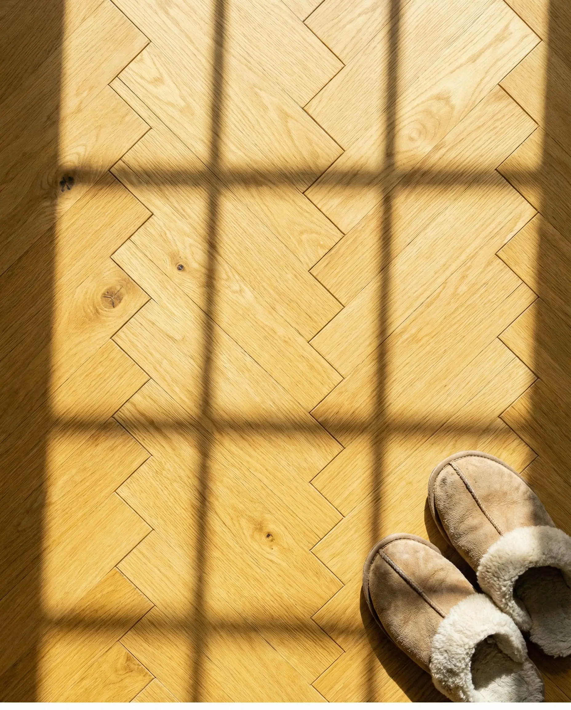 Herringbone wood floor detail in warm honey oak stain.