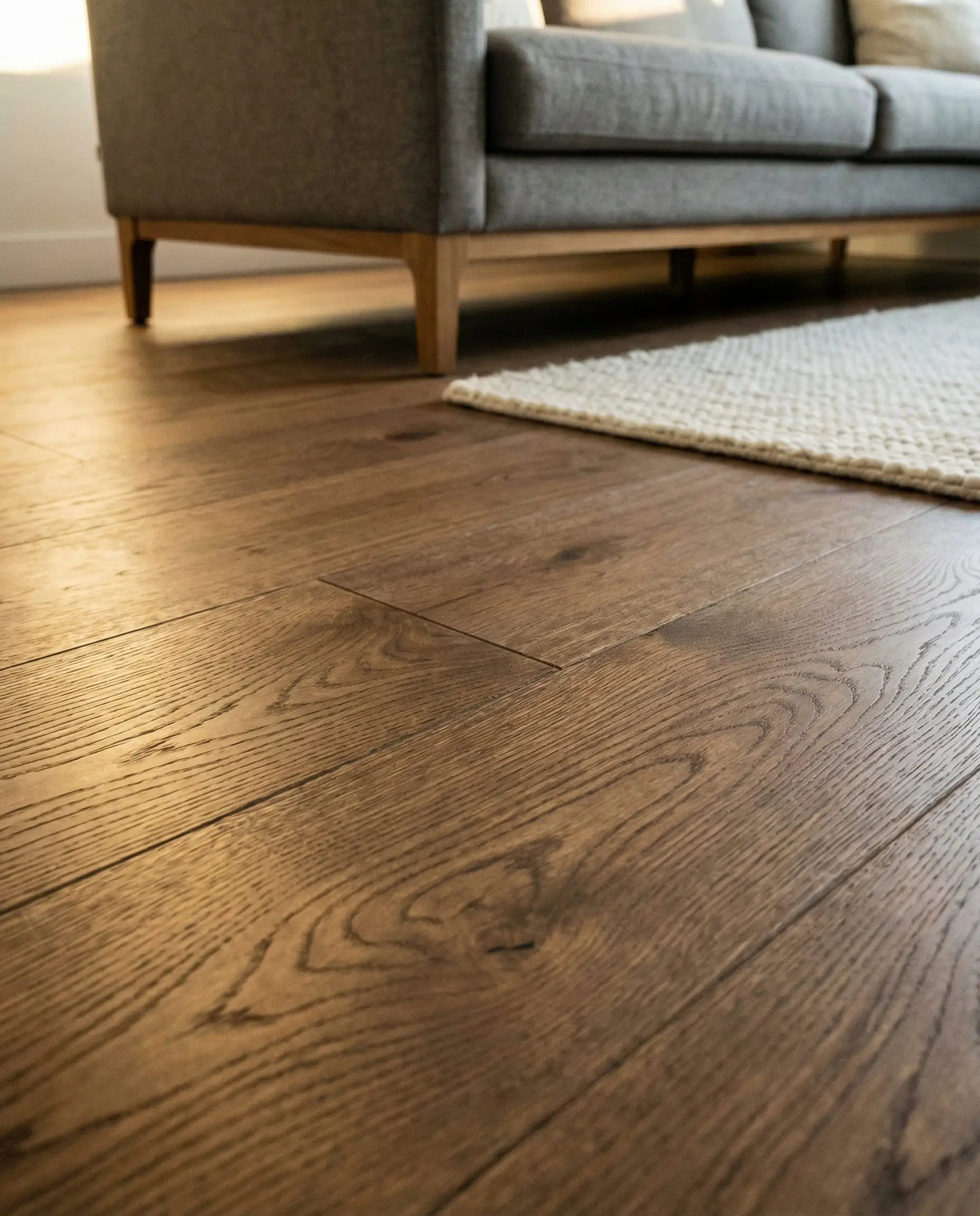 Wide-plank mid-tone walnut wood flooring with matte finish.