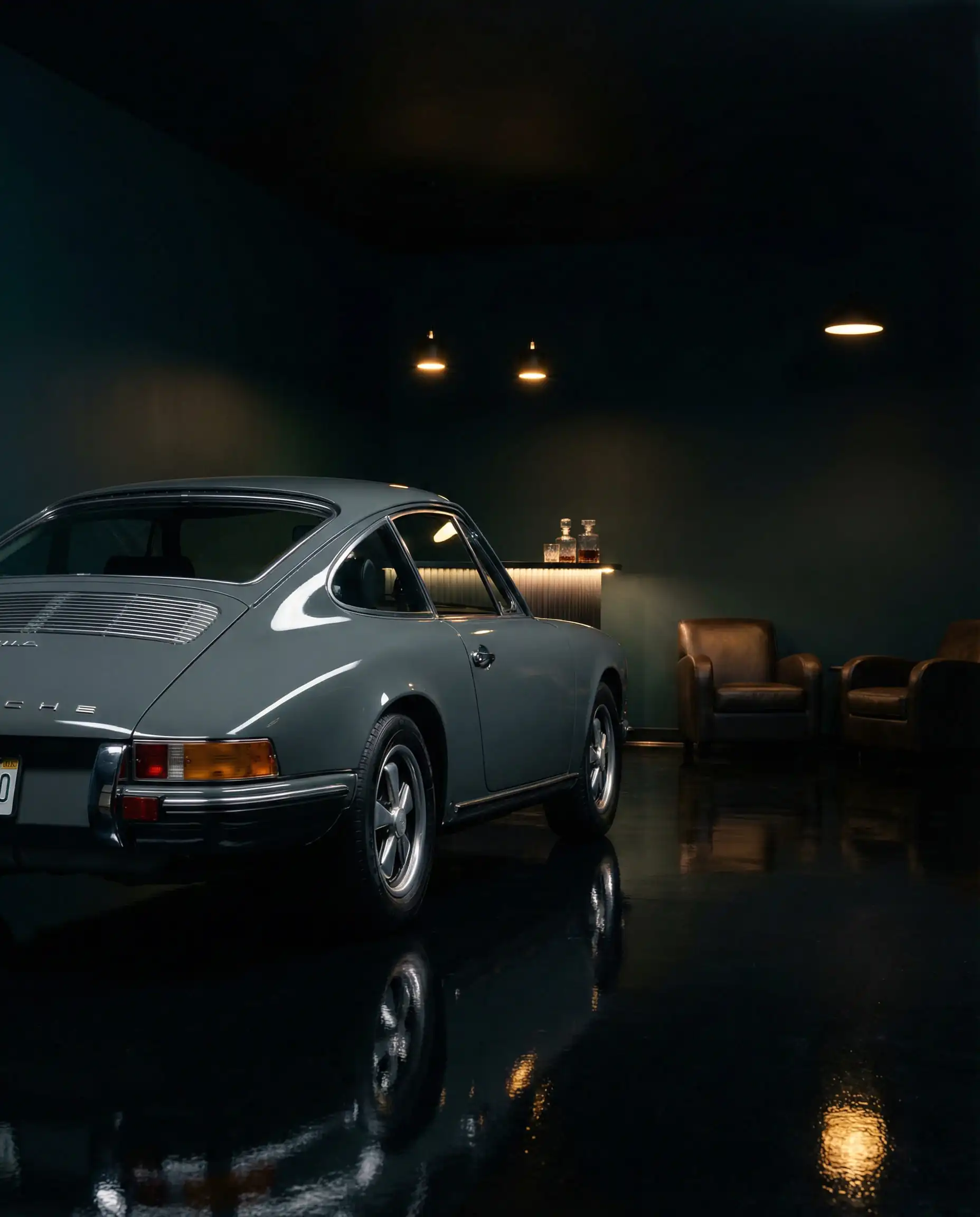 Luxury garage interior with midnight teal walls and a vintage Porsche 911, creating a moody showroom aesthetic.