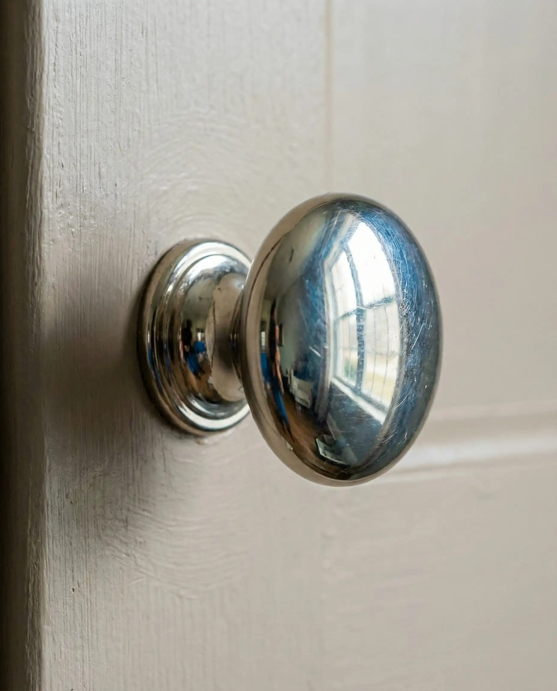 Macro of polished nickel hardware on Sherwin-Williams Shiitake cabinet.