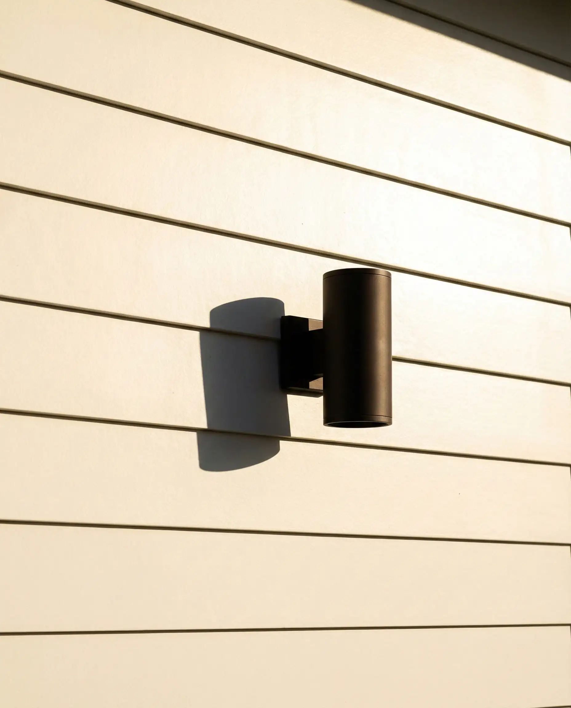 Detail of Sherwin-Williams Alabaster siding contrasting with matte black window frames.