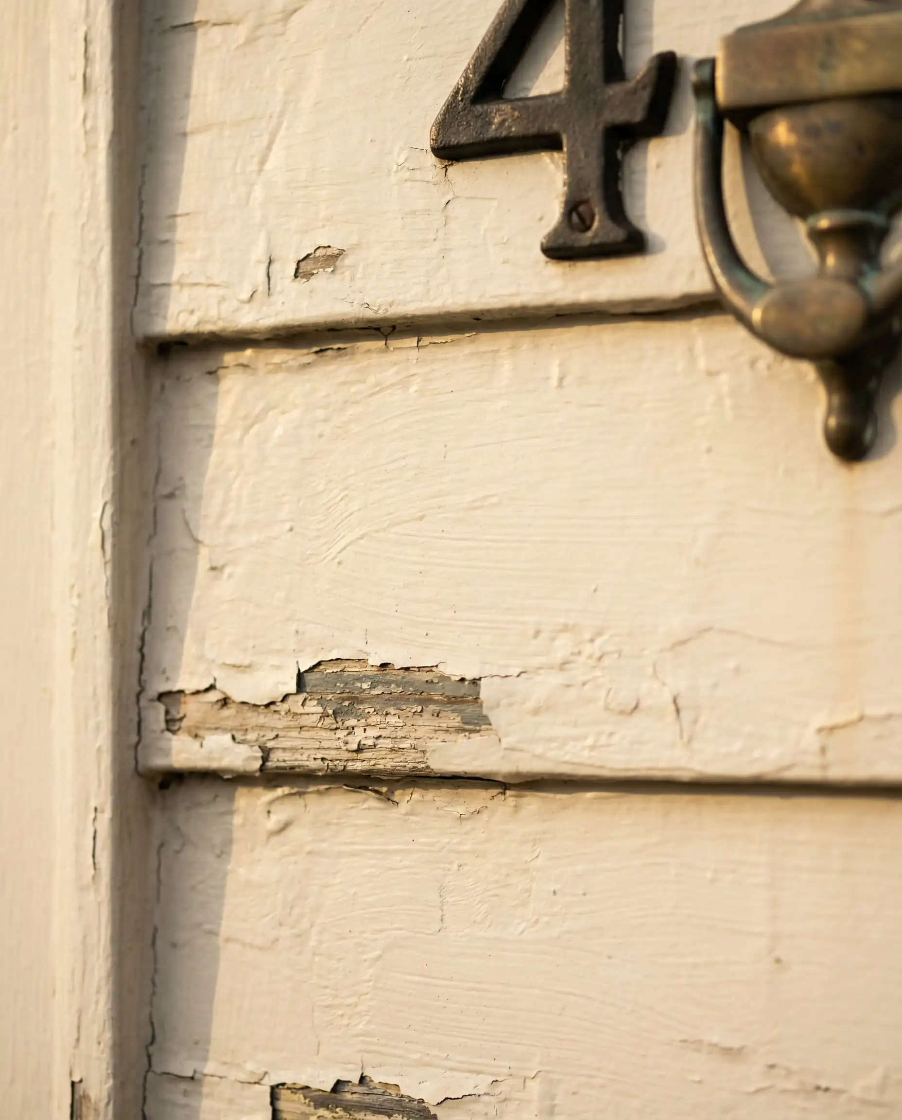 Close-up of antique wood clapboard siding painted in Sherwin-Williams Dover White.
