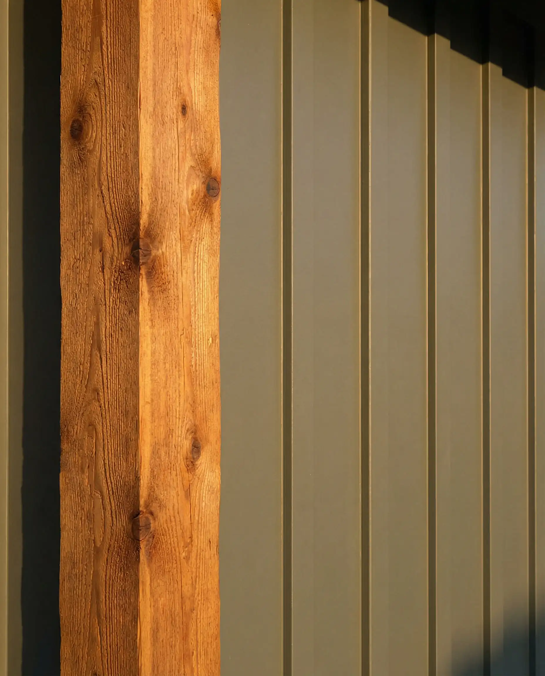Detail of Sherwin-Williams Evergreen Fog siding next to stained cedar timber.