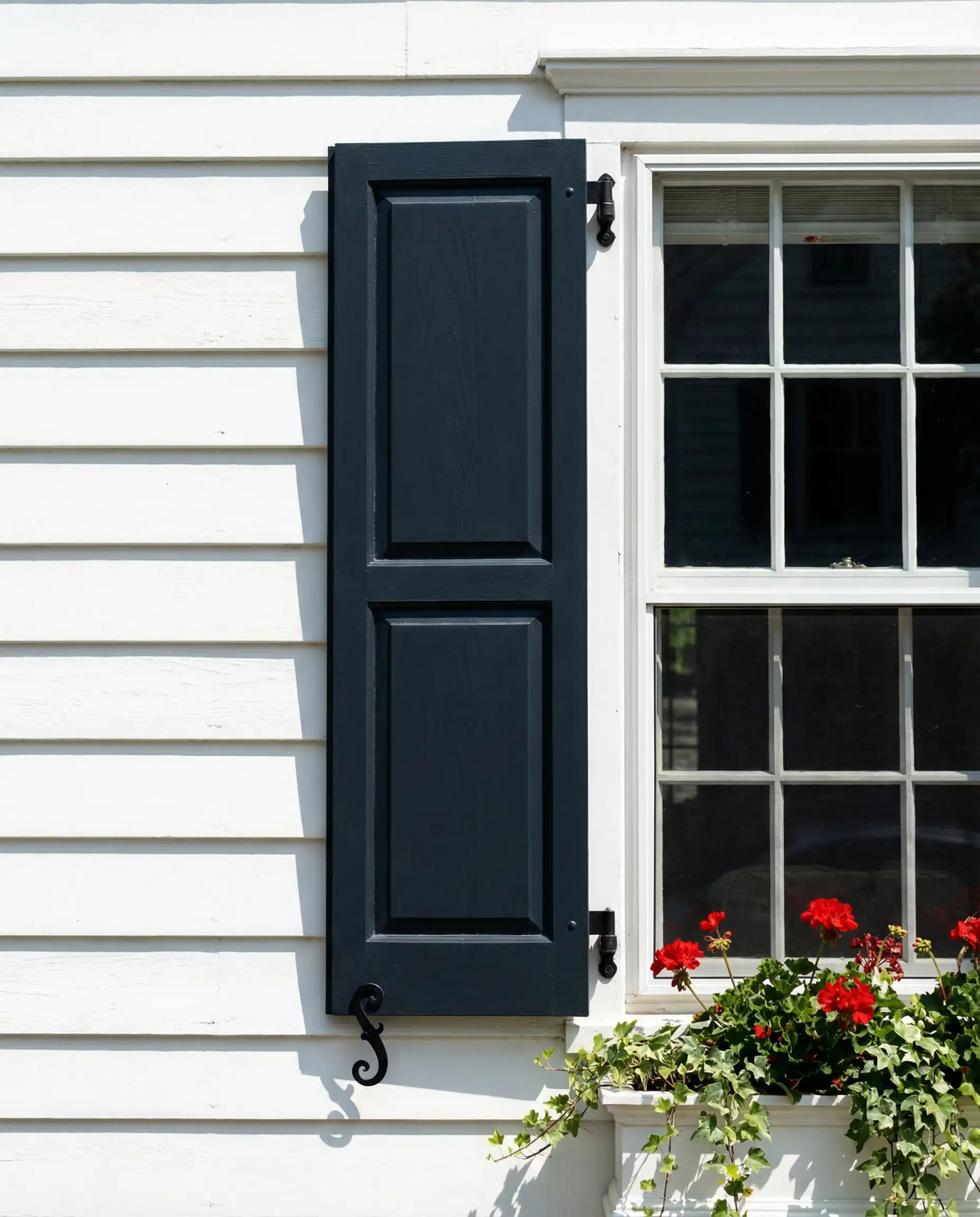 White lap siding with a functional shutter painted in Sherwin-Williams Naval.