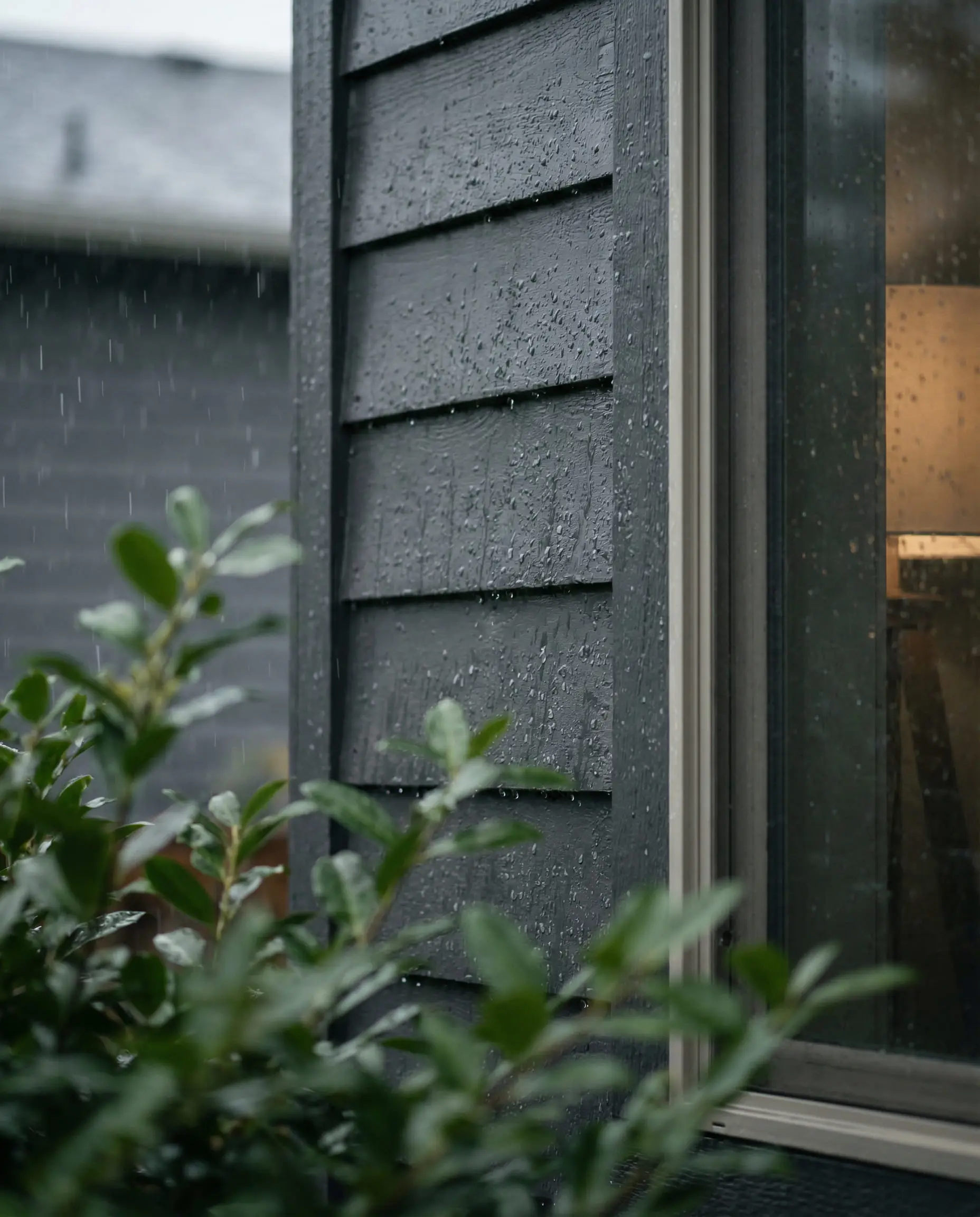 Moody shot of Sherwin-Williams Peppercorn siding during a rainstorm.