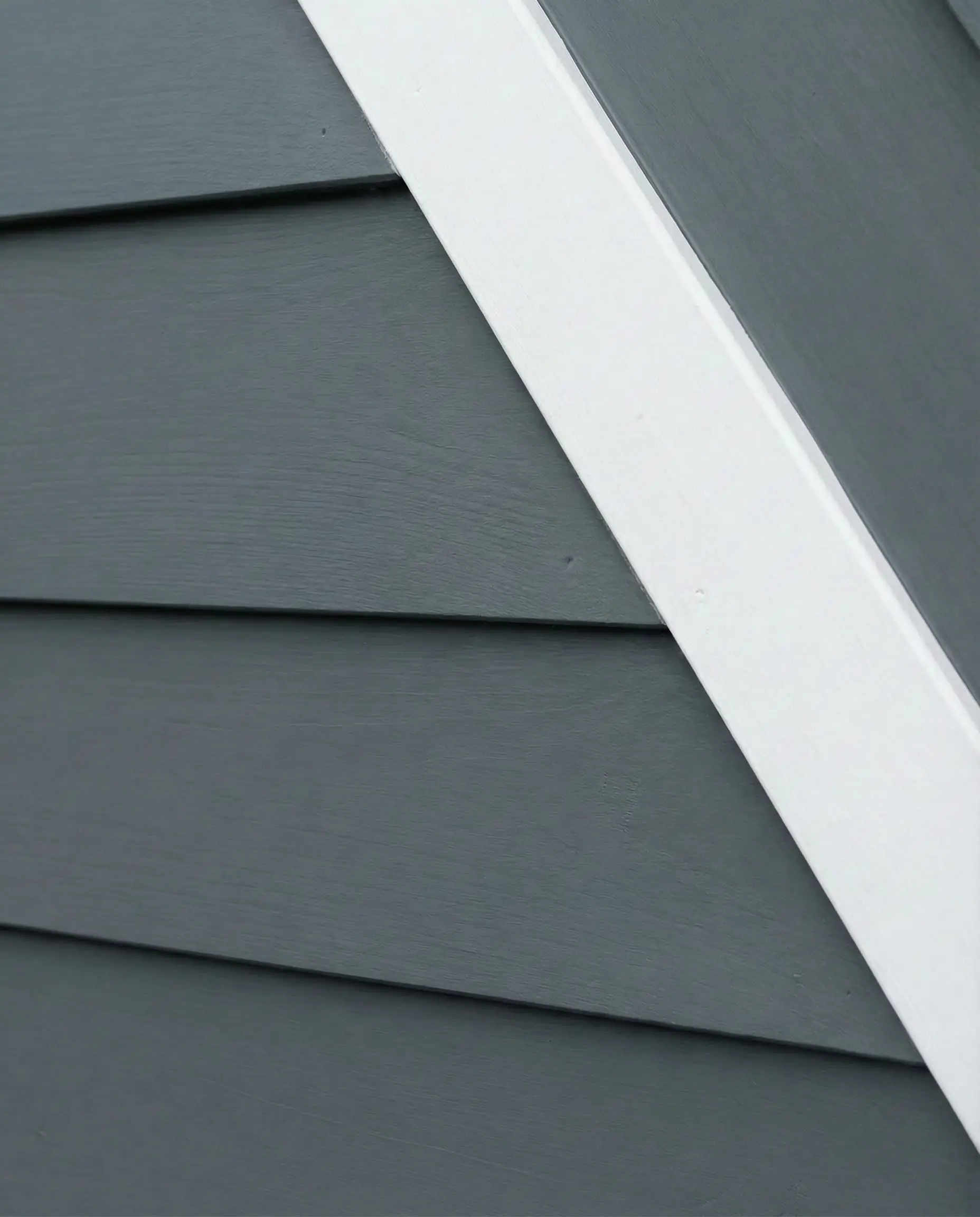Tight shot of lap siding painted in Sherwin-Williams Peppercorn showing gray tones.