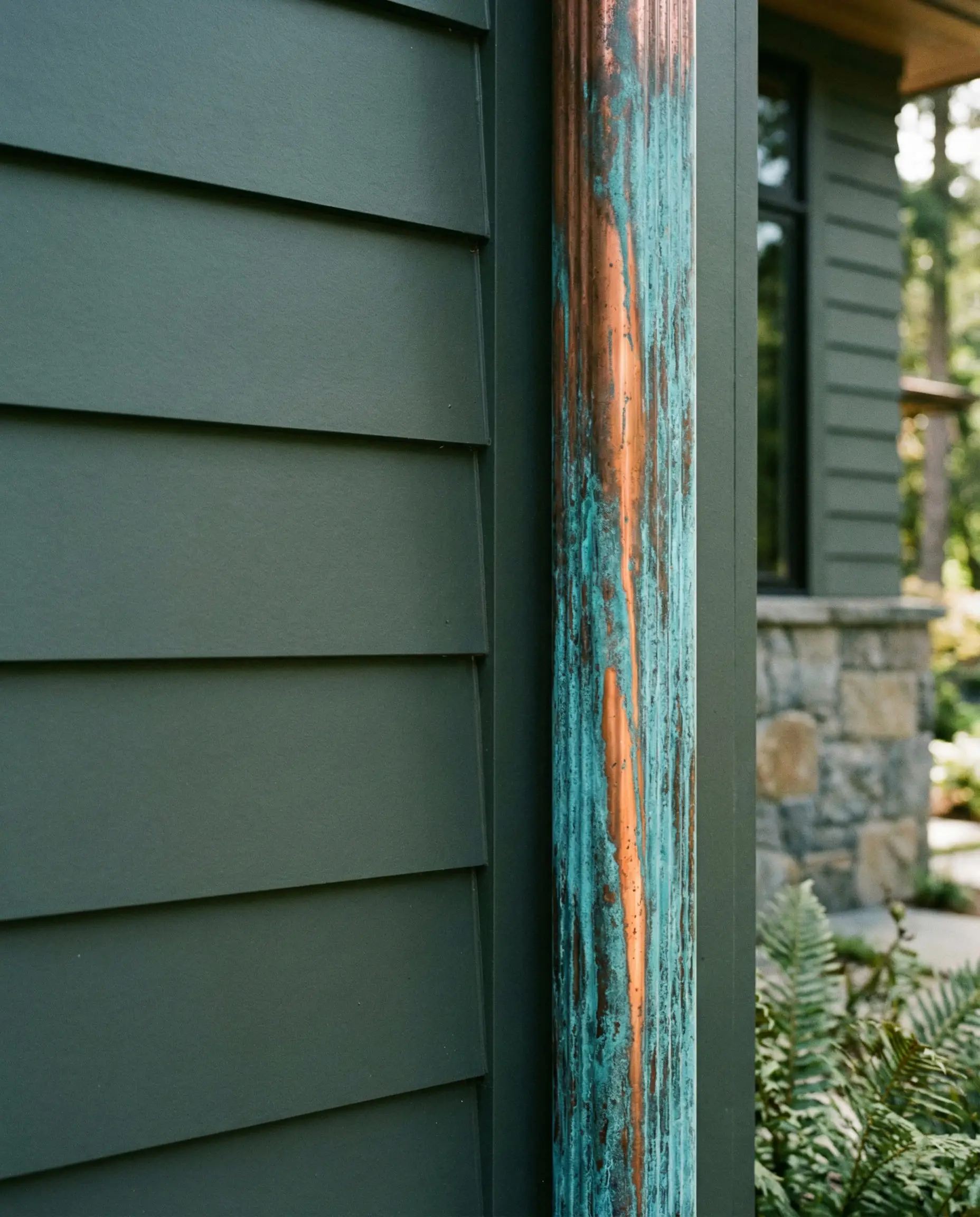 Sherwin-Williams Pewter Green siding paired with copper gutters.