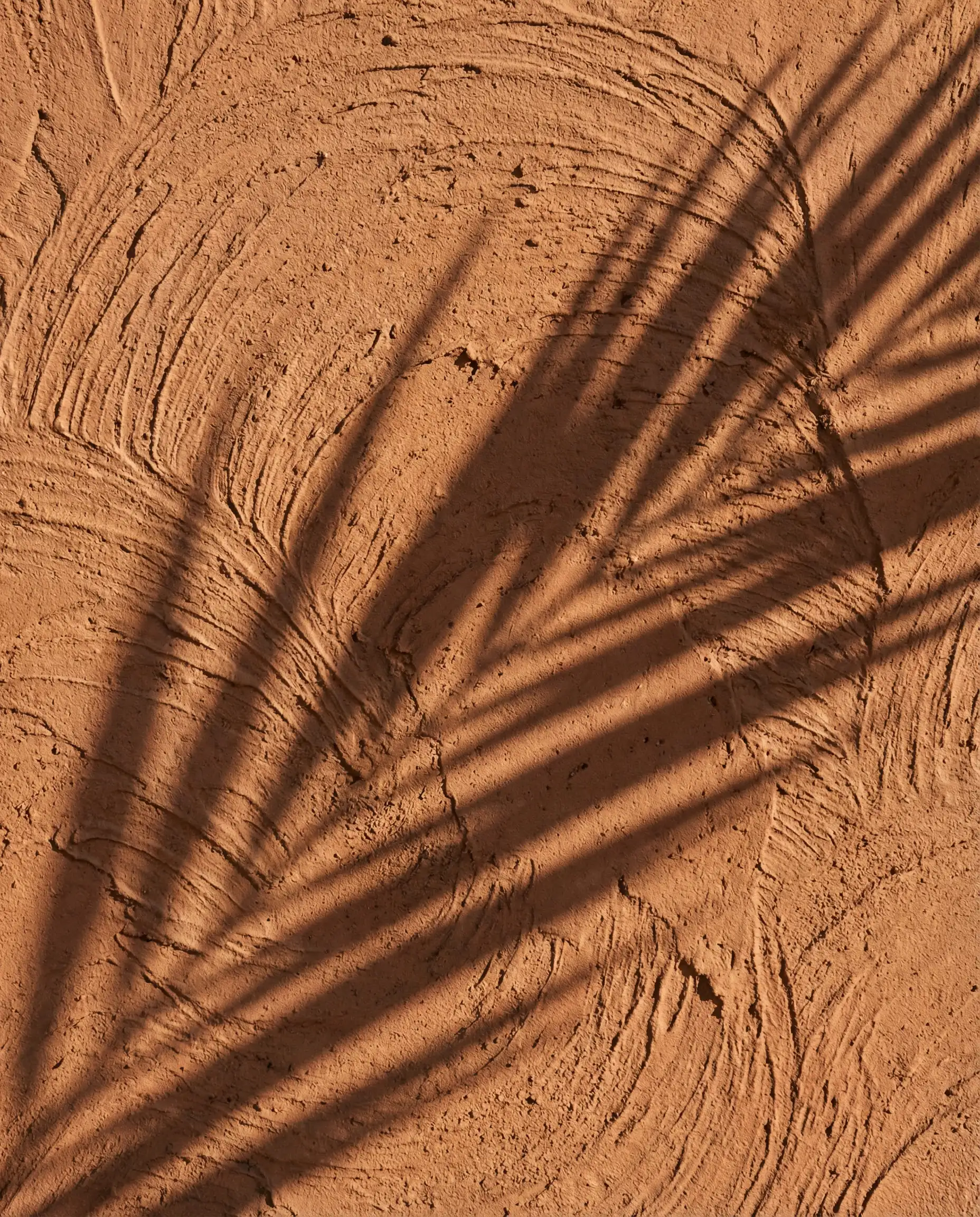 Macro texture of hand-troweled exterior plaster painted in Sherwin-Williams Redend Point.