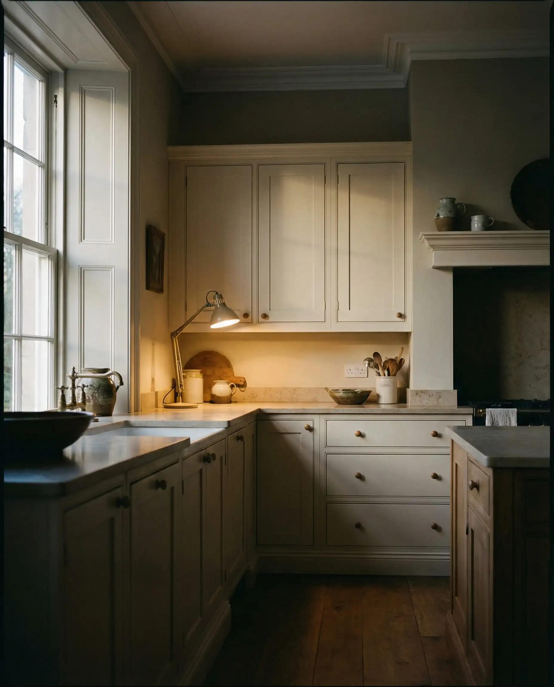 Kitchen at twilight showing Sherwin-Williams Shoji White cabinets shifting from cream to greige in shadow.