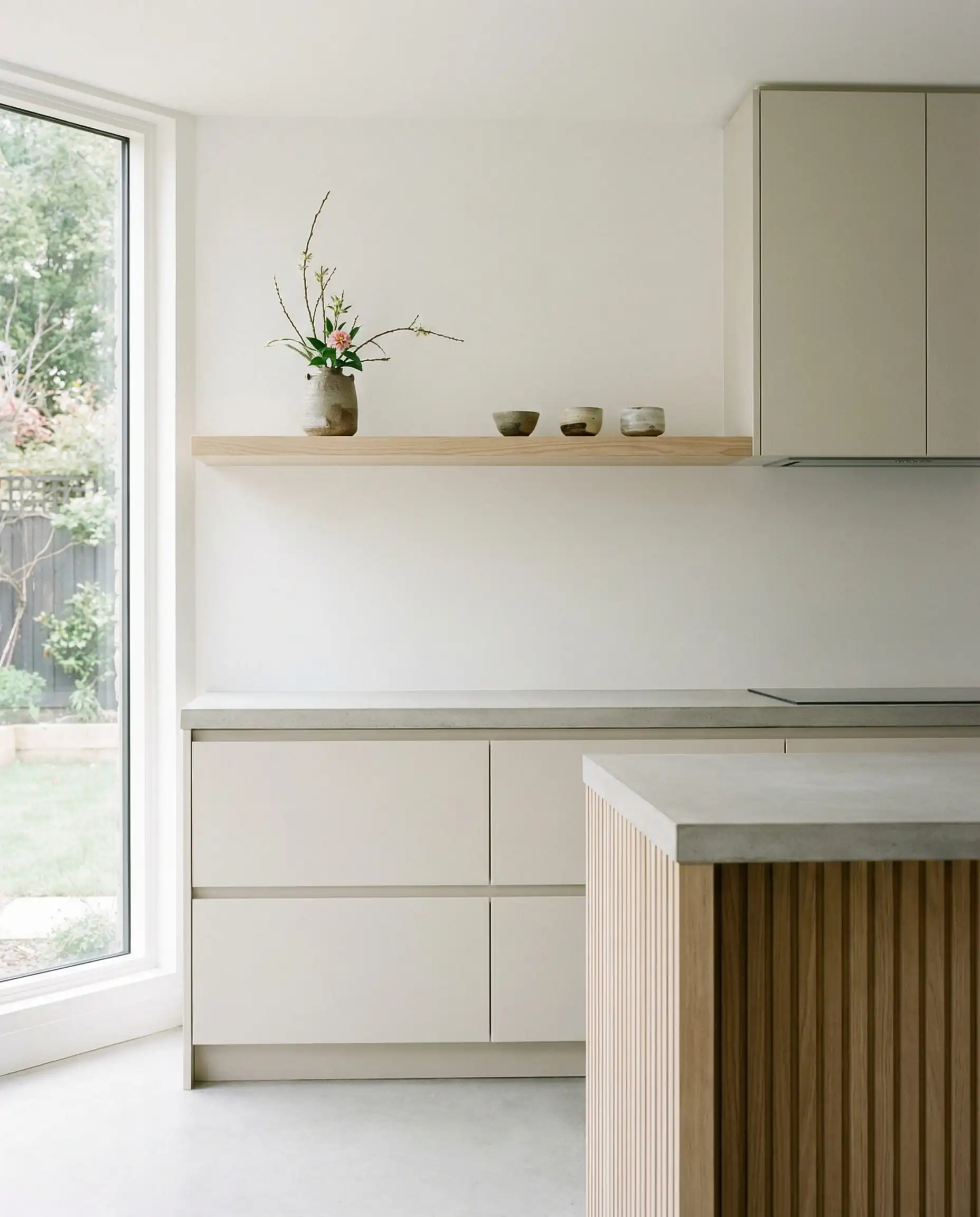 Minimalist Japandi kitchen with slab cabinets painted in Sherwin-Williams Shoji White SW 7042.