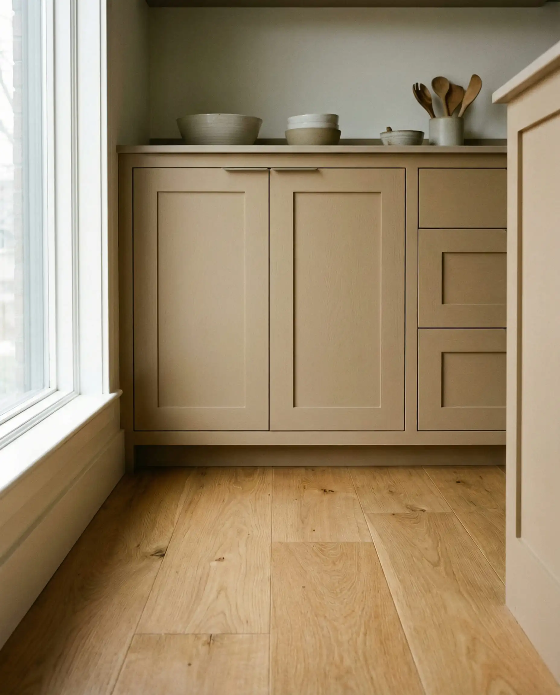 Sherwin-Williams Universal Khaki cabinets paired with white oak flooring.