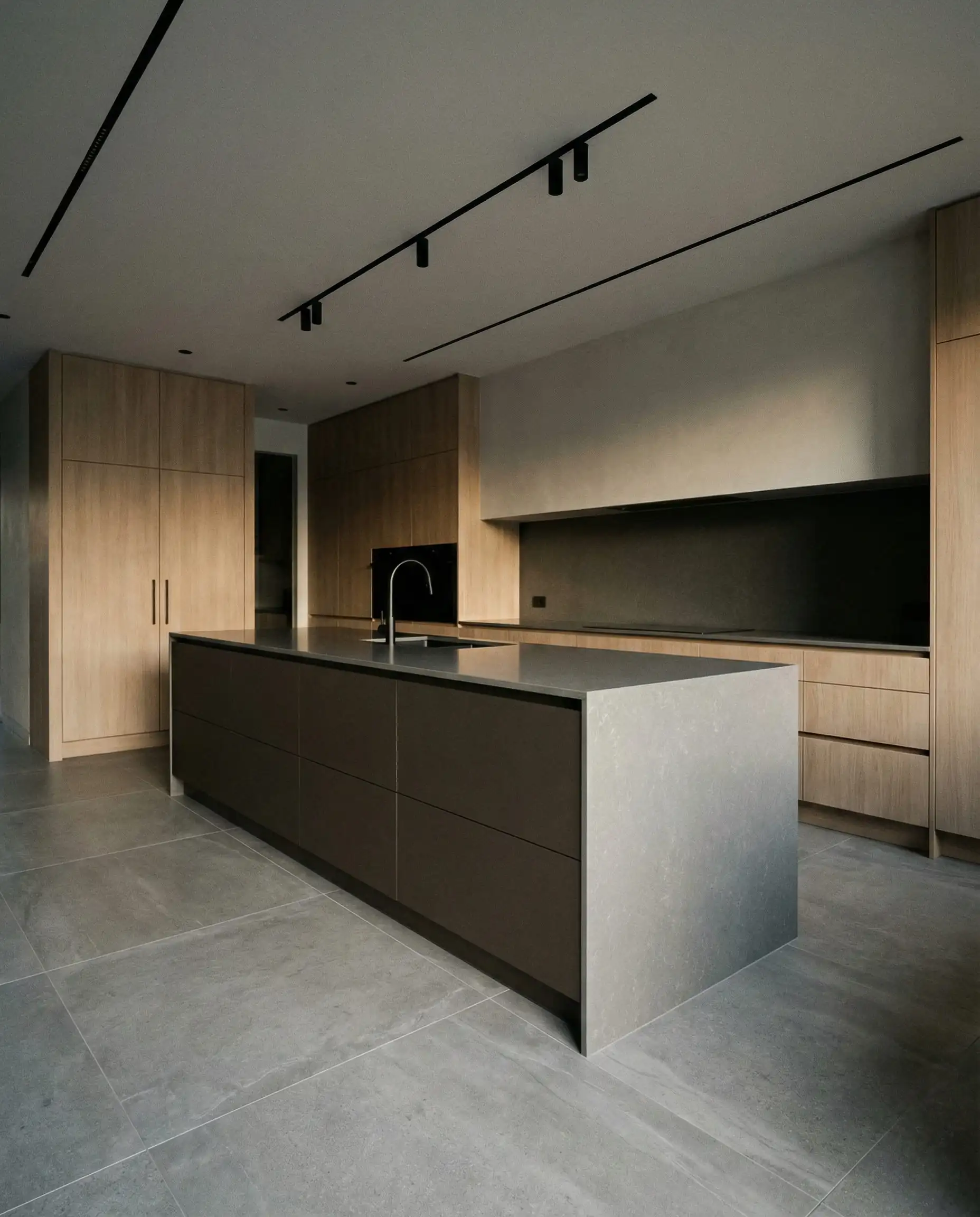 Modern kitchen island painted in Sherwin-Williams Urbane Bronze SW 7048 with grey quartz.