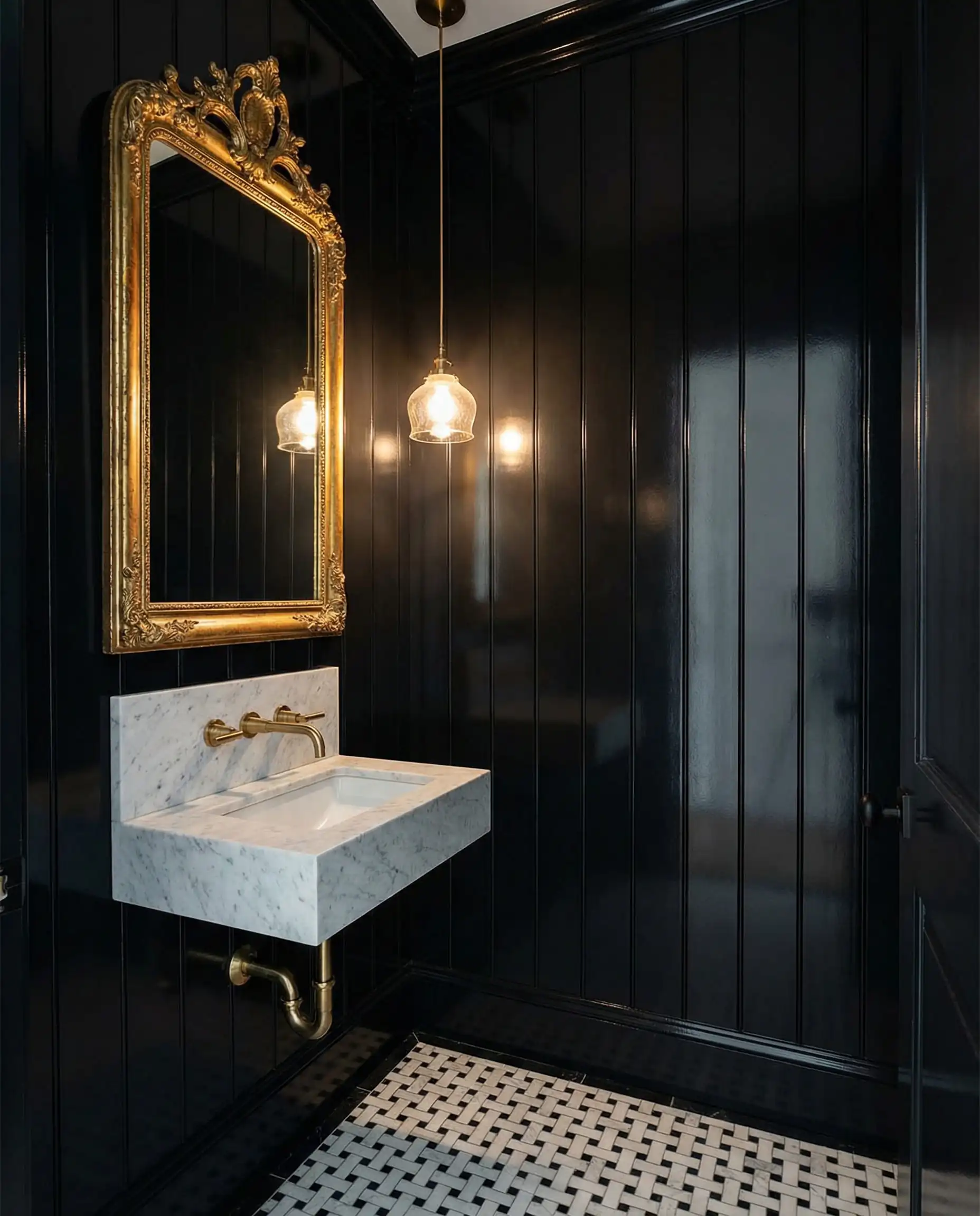 Luxurious small bathroom with floor-to-ceiling black board and batten walls and gold mirror.