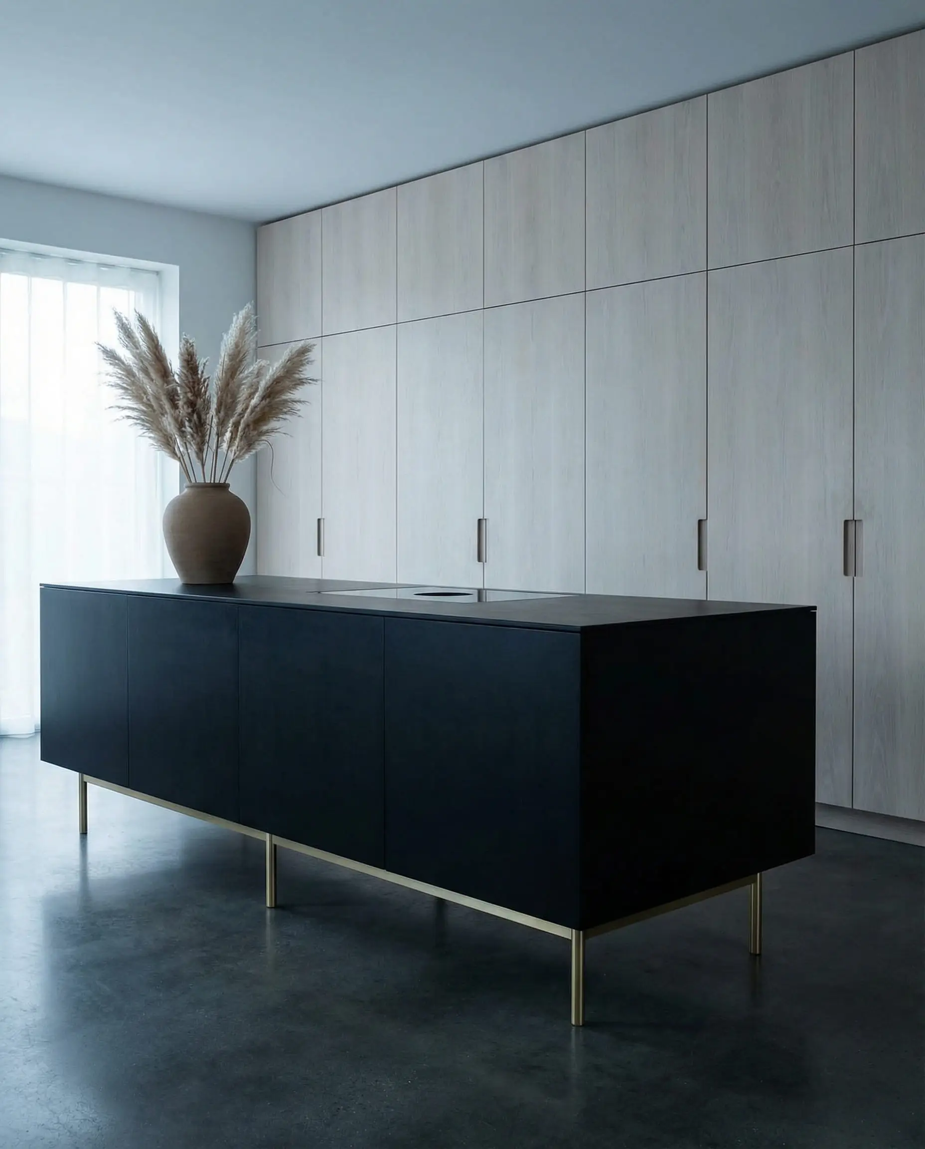 Modern Scandinavian kitchen featuring a matte black island on gold legs set against a wall of light white oak cabinetry.