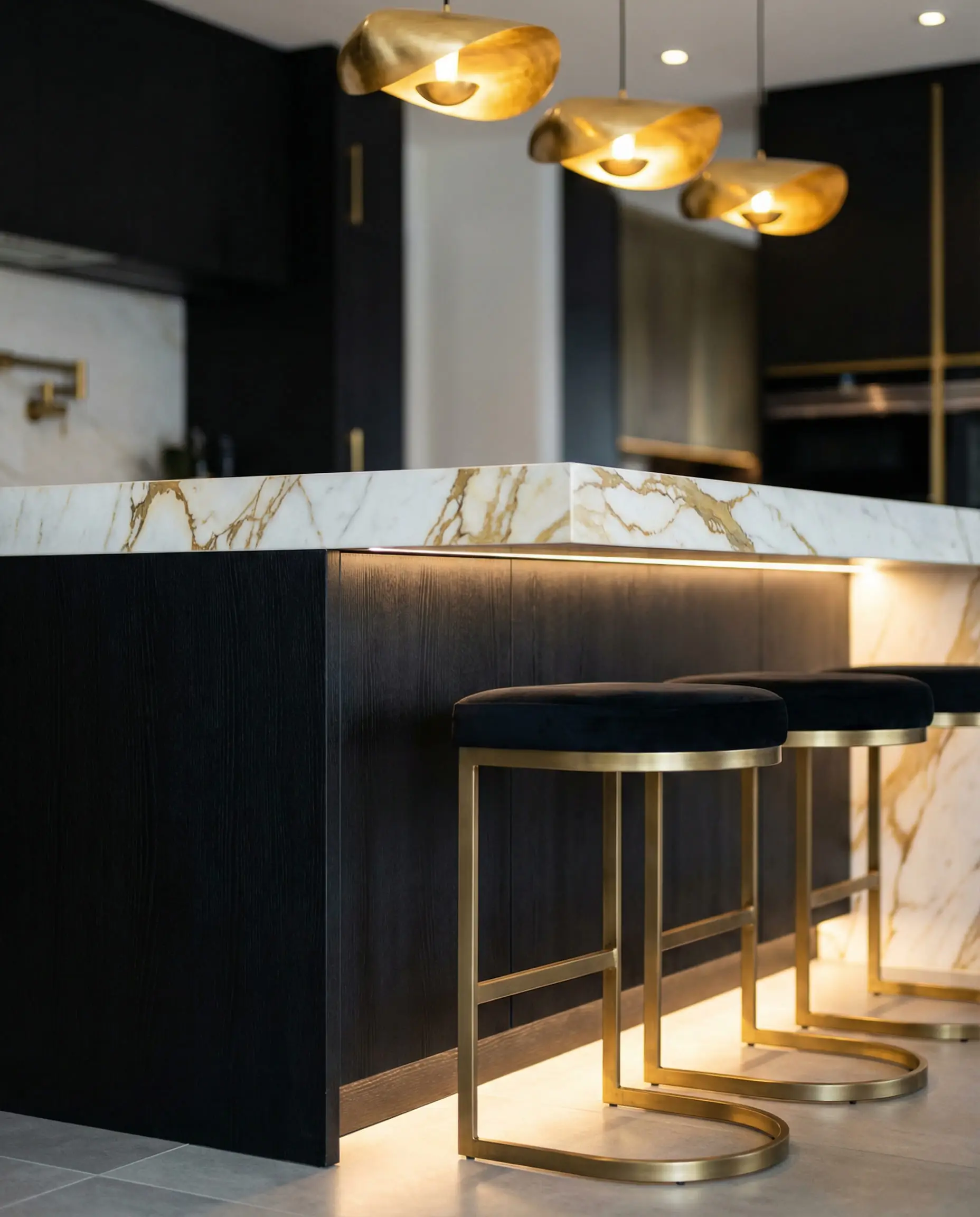 Luxury kitchen island in black oak with waterfall white and gold-veined marble.