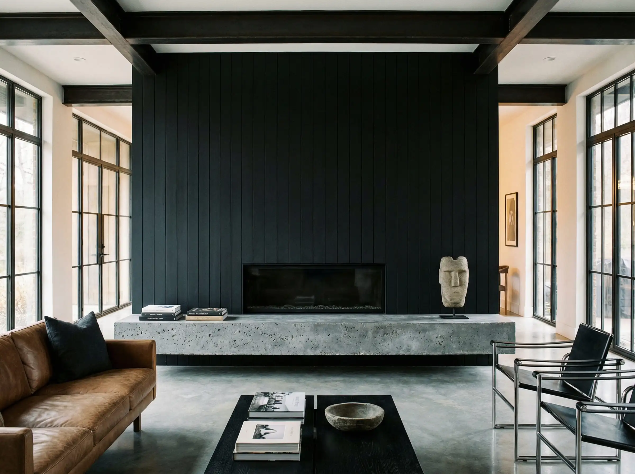 Modern fireplace with vertical black cladding and a floating raw concrete hearth bench.