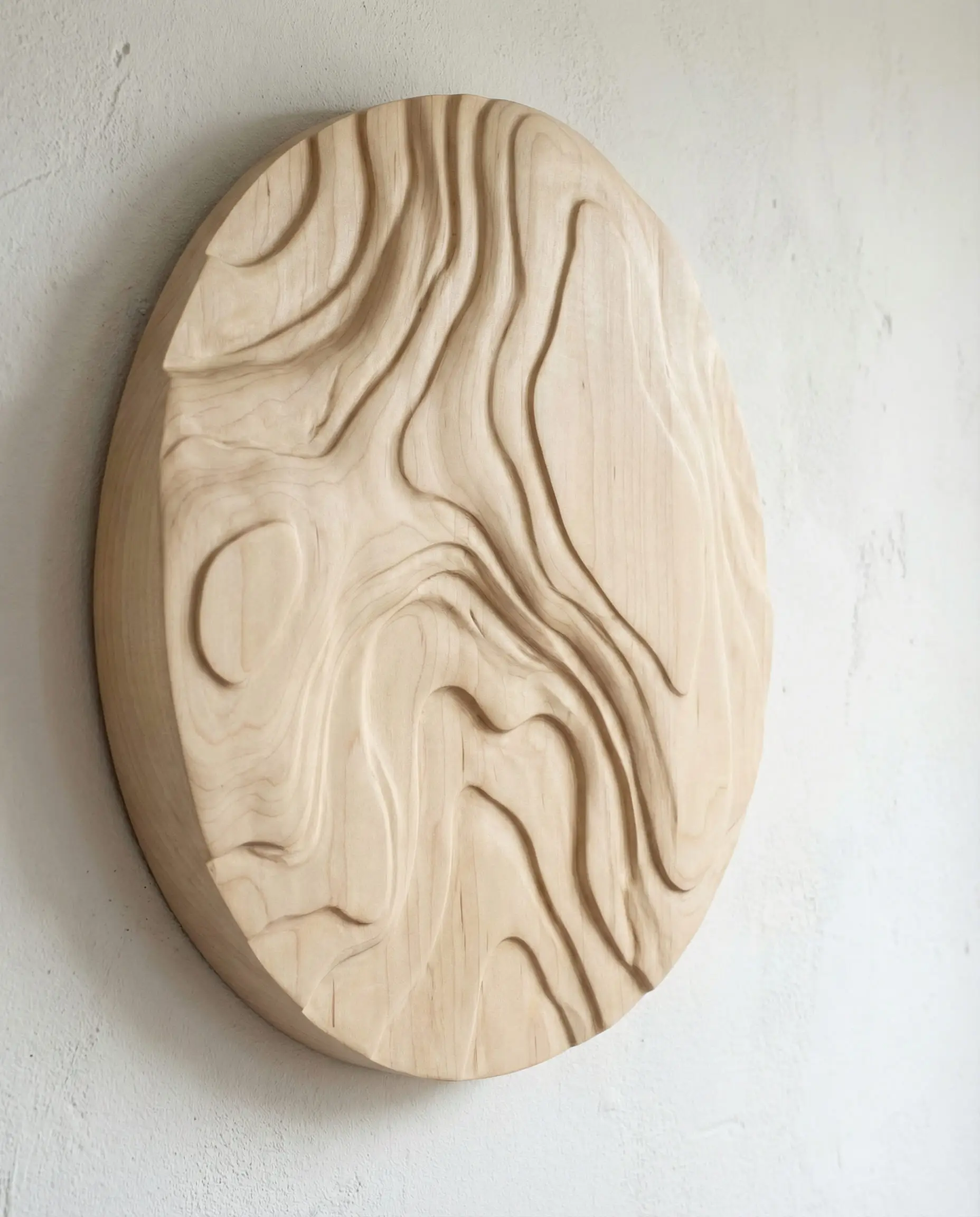 Close up of a blonde birch wood relief art panel with organic topographical carving.