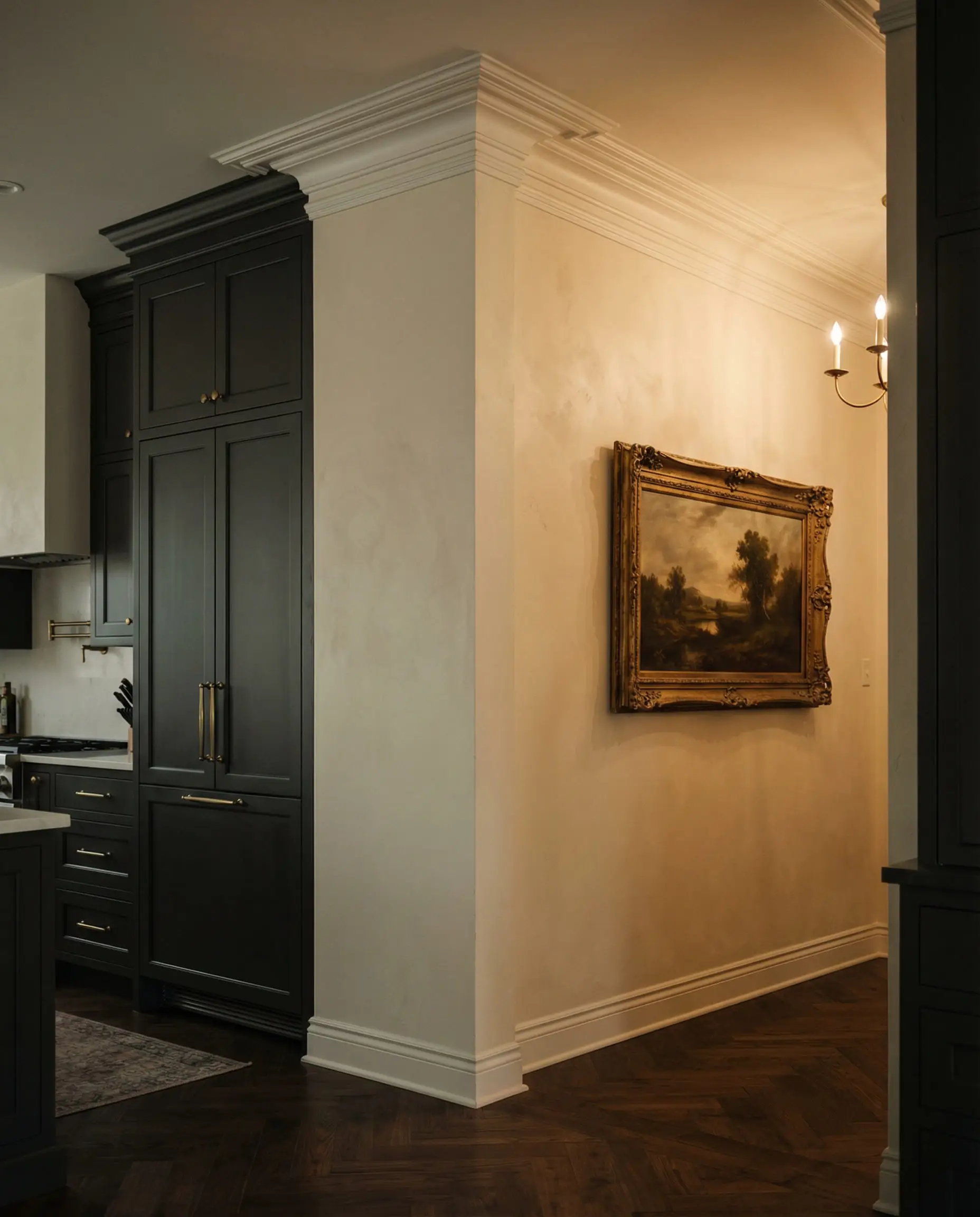 Transition space showing deep charcoal gray cabinetry contrasting with rich creamy off-white walls and vintage gold art frames.