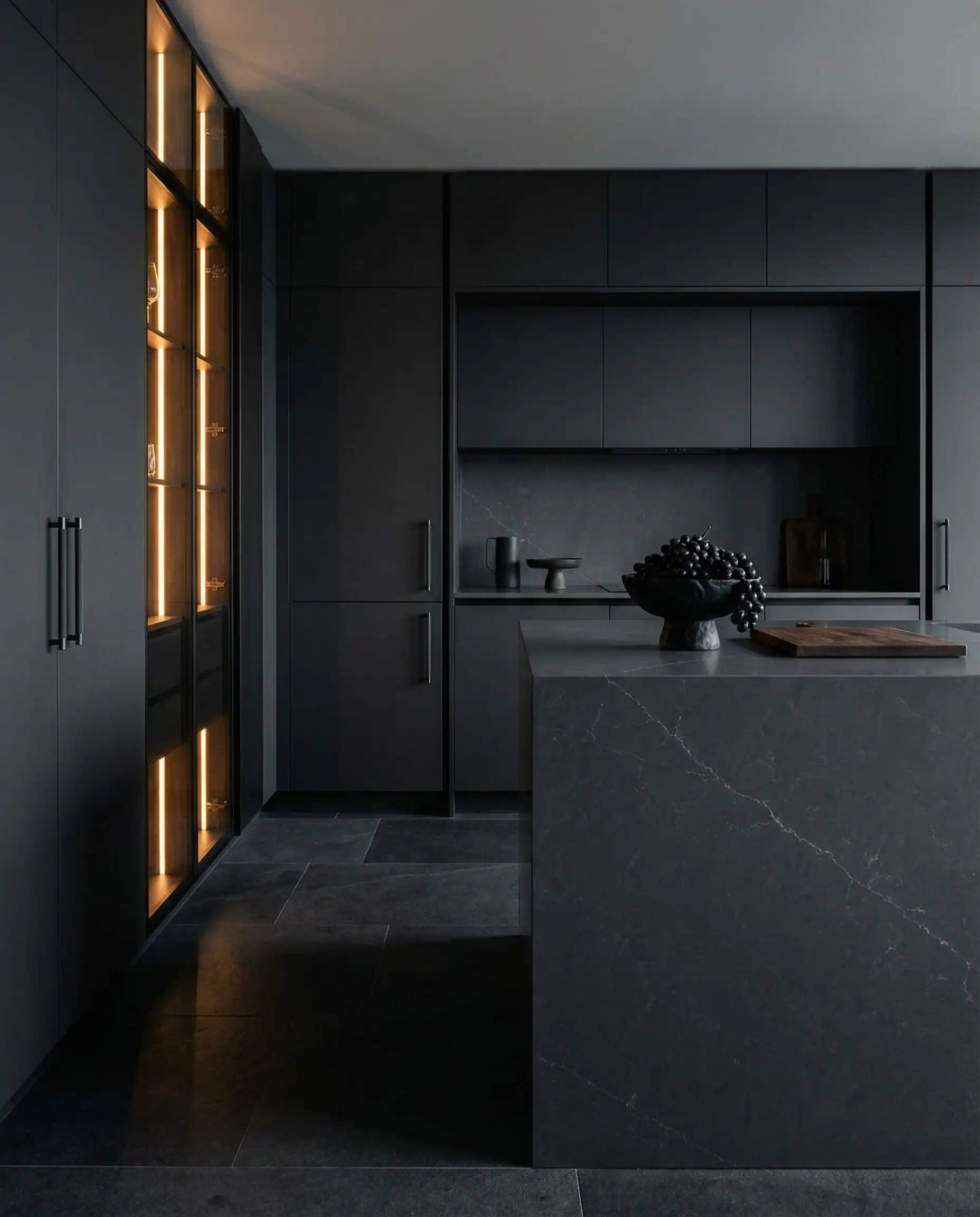Sophisticated monochromatic kitchen with charcoal gray cabinets matching the deep gray stone flooring.