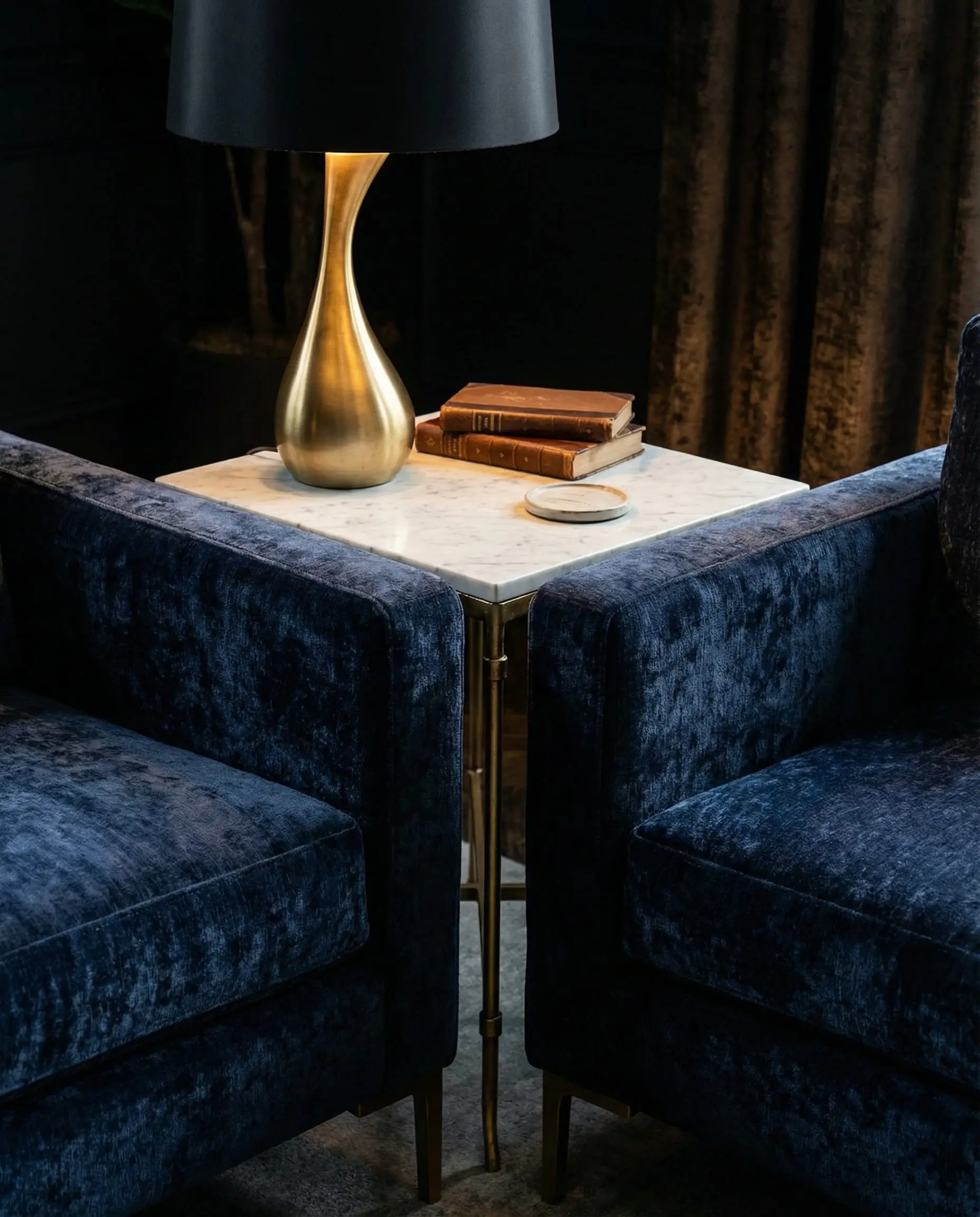 Close-up detail of the corner gap between two perpendicular sofas, styled with a marble side table and a brass lamp.