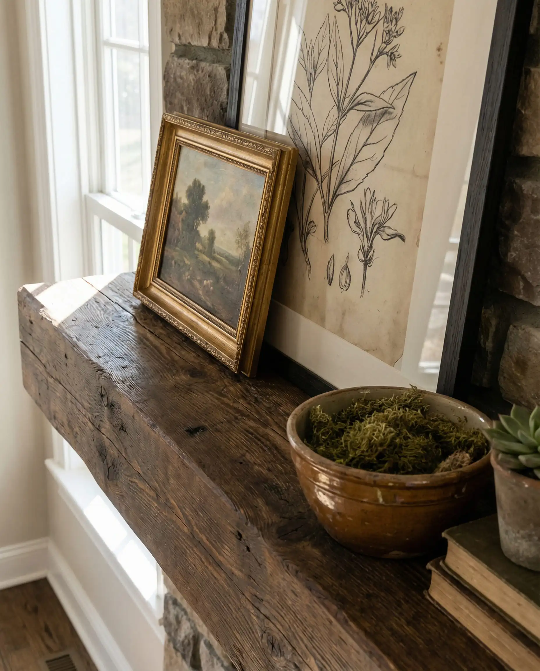 Top-down detail shot of an 8-inch deep wood mantel styled with layered picture frames and ceramic decor.